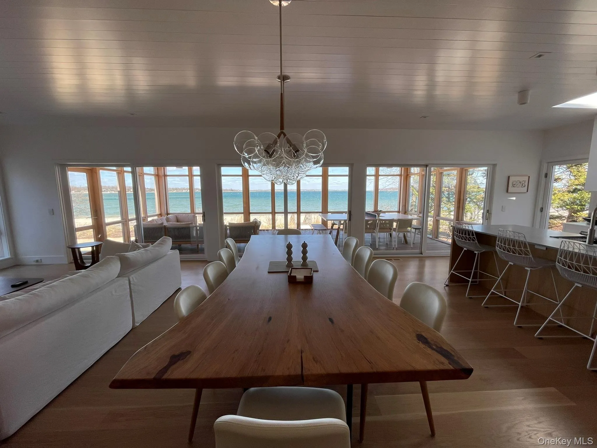 Dining room with a water view, an inviting chandelier, and wood finished floors Dining room with a water view, an inviting chandelier, and wood finished floors