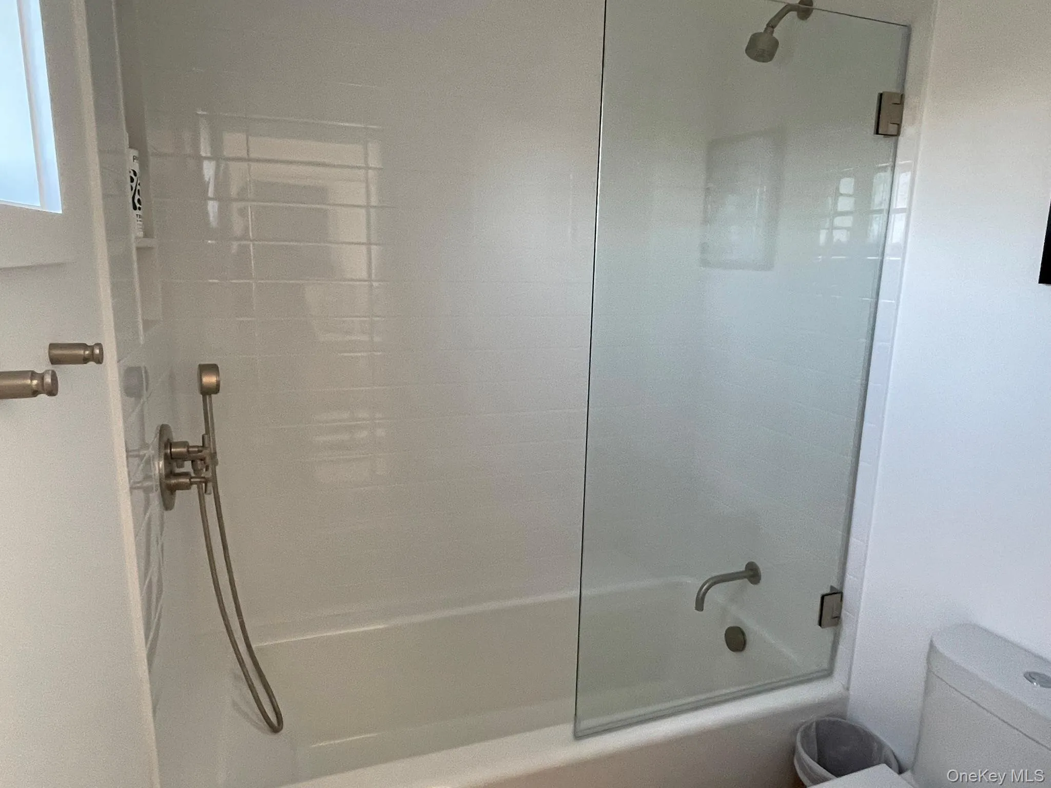 Full bathroom featuring toilet and combined bath / shower with glass door Full bathroom featuring toilet and combined bath / shower with glass door