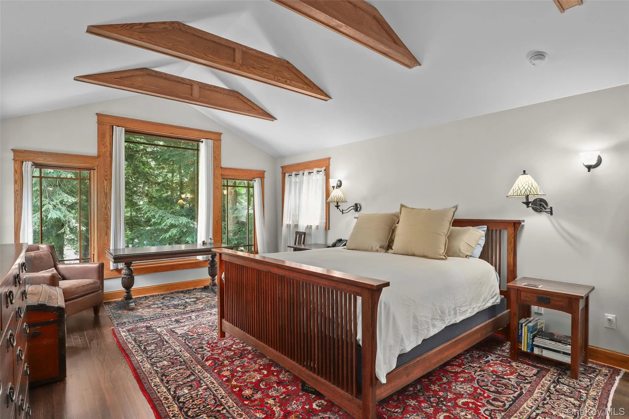 Primary bedroom with kingsize bed, en suite bath with spa-style steam shower, and views of lake and wooded hillside. Primary bedroom with kingsize bed, en suite bath with spa-style steam shower, and views of lake and wooded hillside.