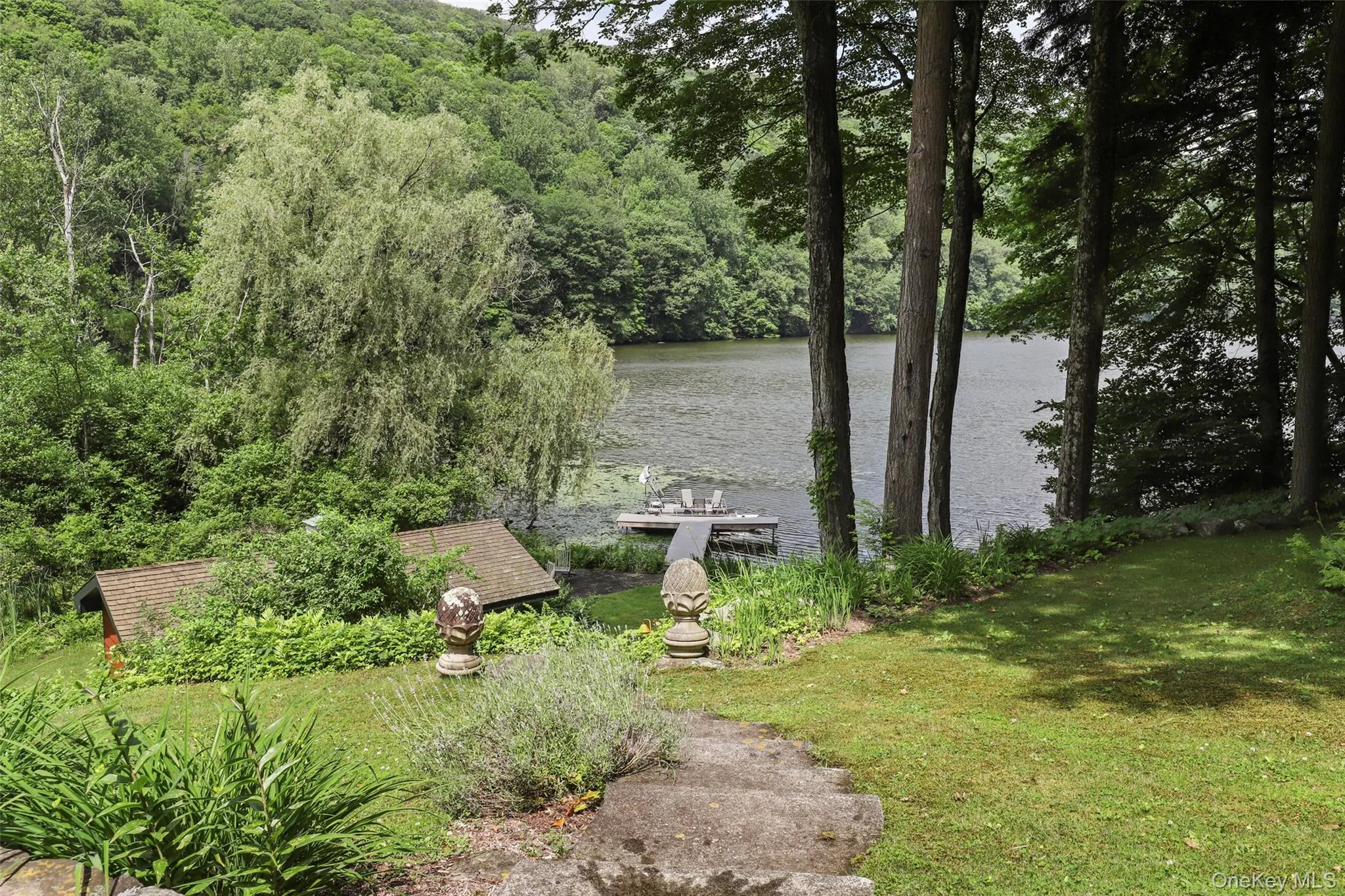 Yard with steps down to private lakefront with dock and watercraft. Yard with steps down to private lakefront with dock and watercraft.