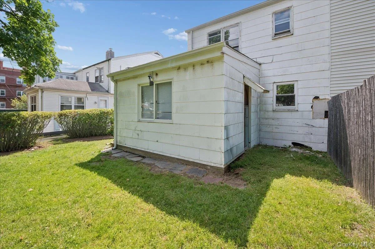 Expansive grassy backyard featuring a detached accessory structure, mature perimeter shrubs, and a privacy fence Expansive grassy backyard featuring a detached accessory structure, mature perimeter shrubs, and a privacy fence