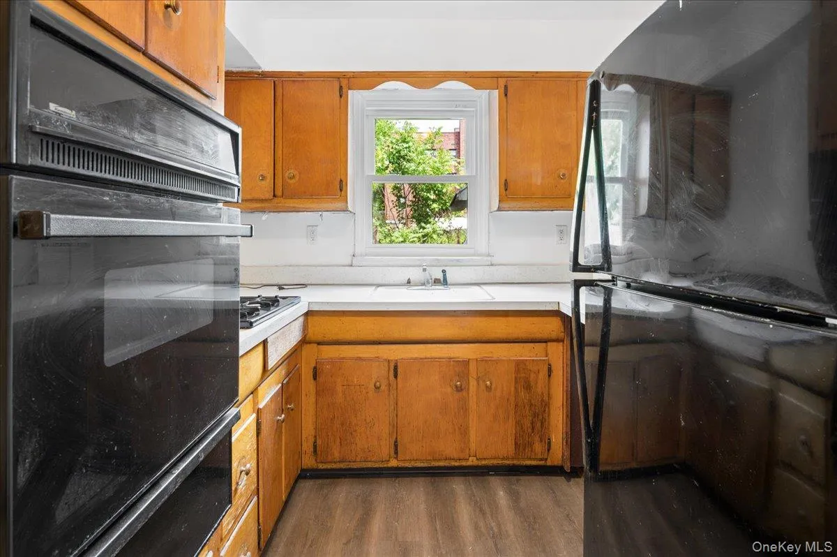 Kitchen featuring wood-finish cabinetry, white countertops, built-in double ovens, and a gas cooktop Kitchen featuring wood-finish cabinetry, white countertops, built-in double ovens, and a gas cooktop