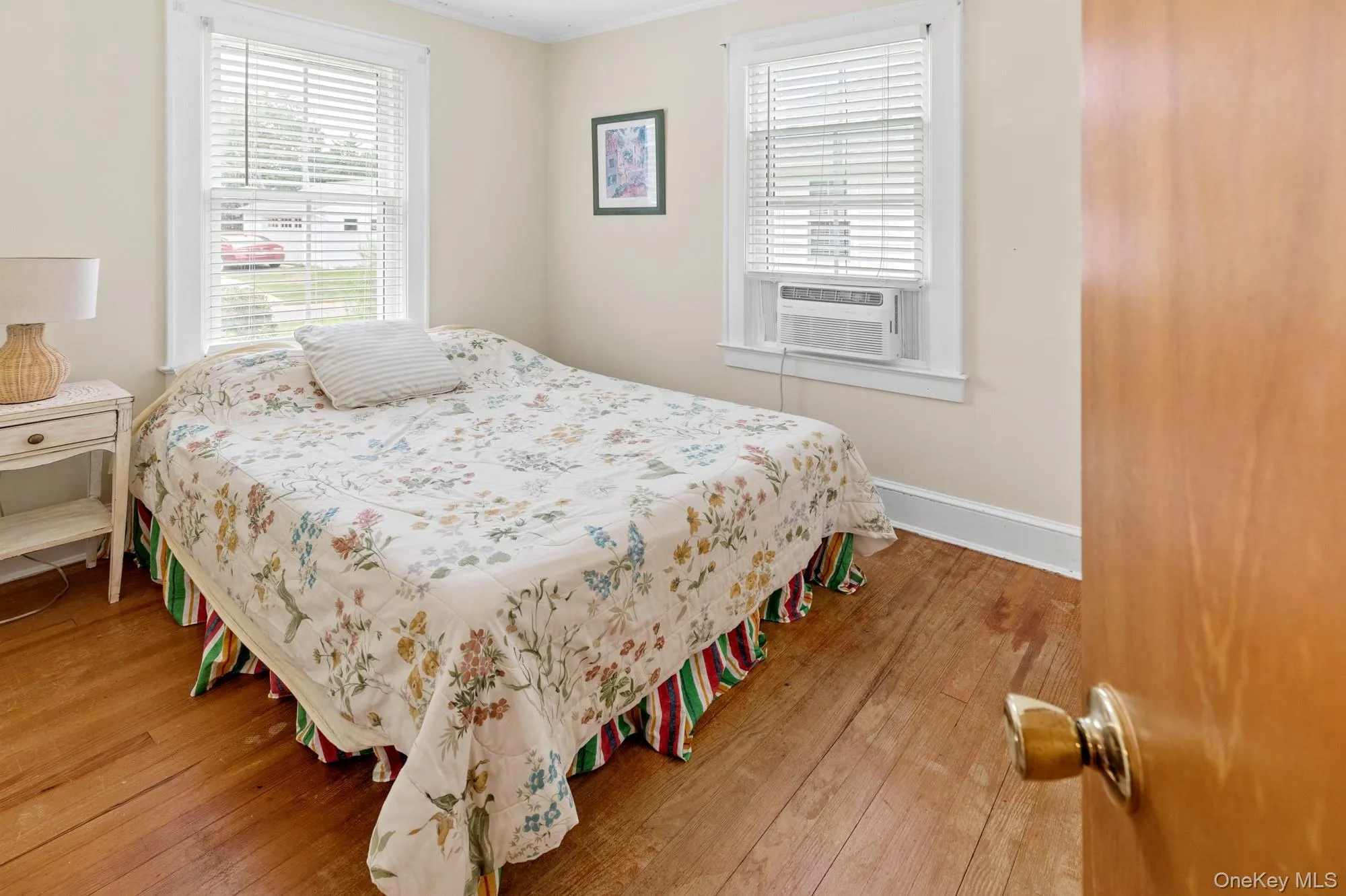 Bedroom featuring ornamental molding, light wood-style flooring, and cooling unit Bedroom featuring ornamental molding, light wood-style flooring, and cooling unit