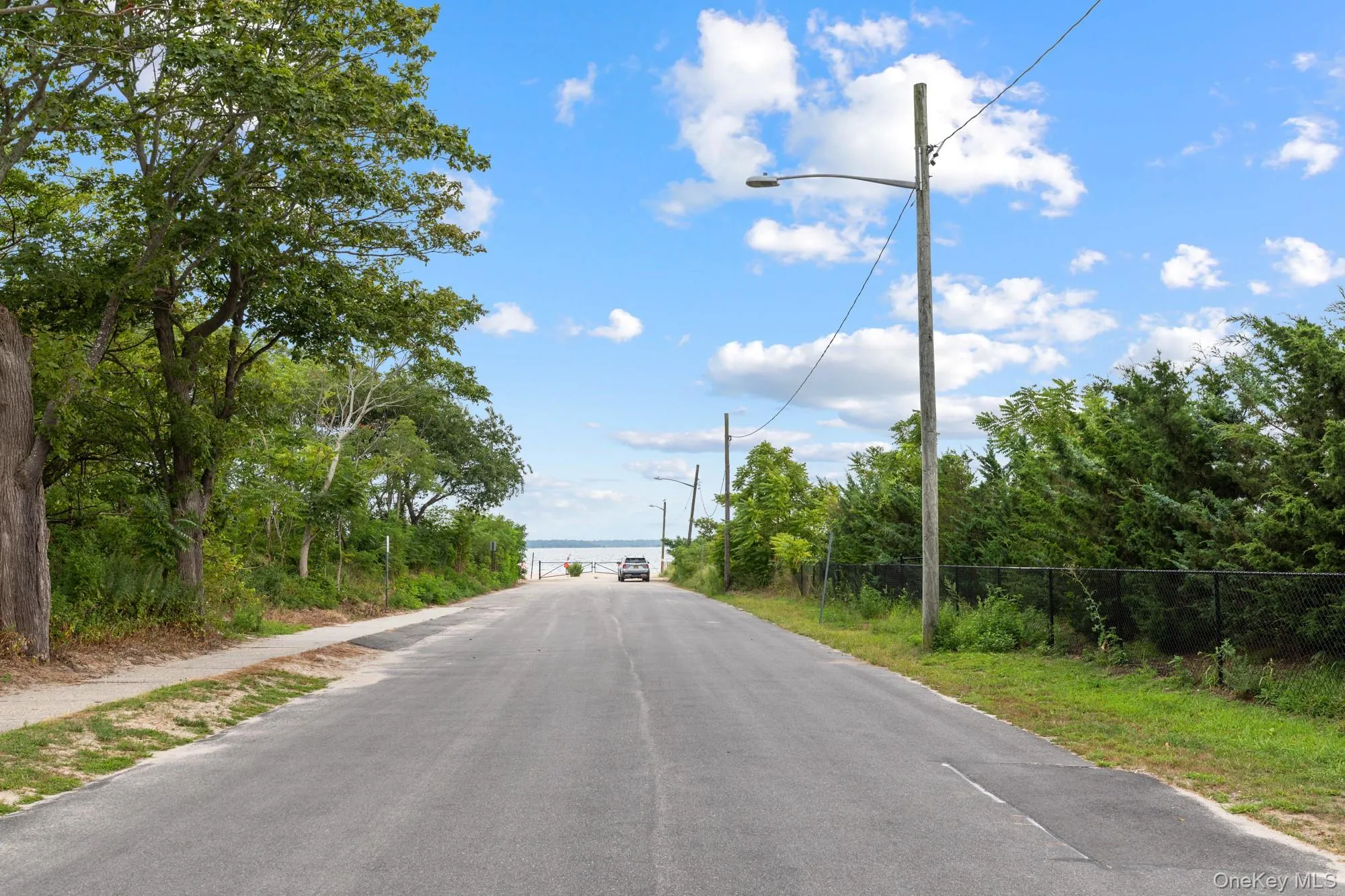 View of asphalt street with street lights and sidewalks View of asphalt street with street lights and sidewalks