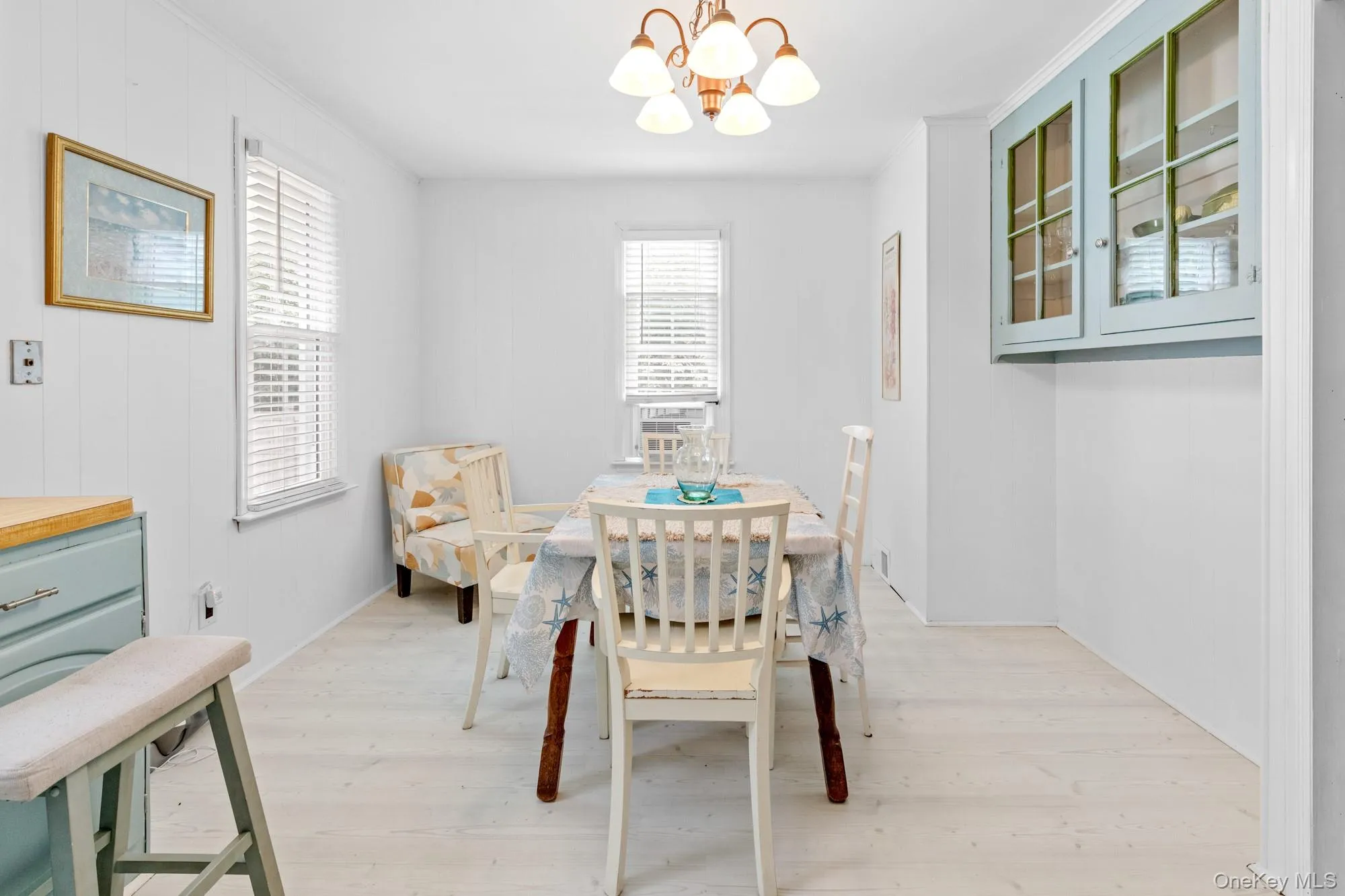 Dining room featuring light wood-style flooring, a chandelier, and crown molding Dining room featuring light wood-style flooring, a chandelier, and crown molding