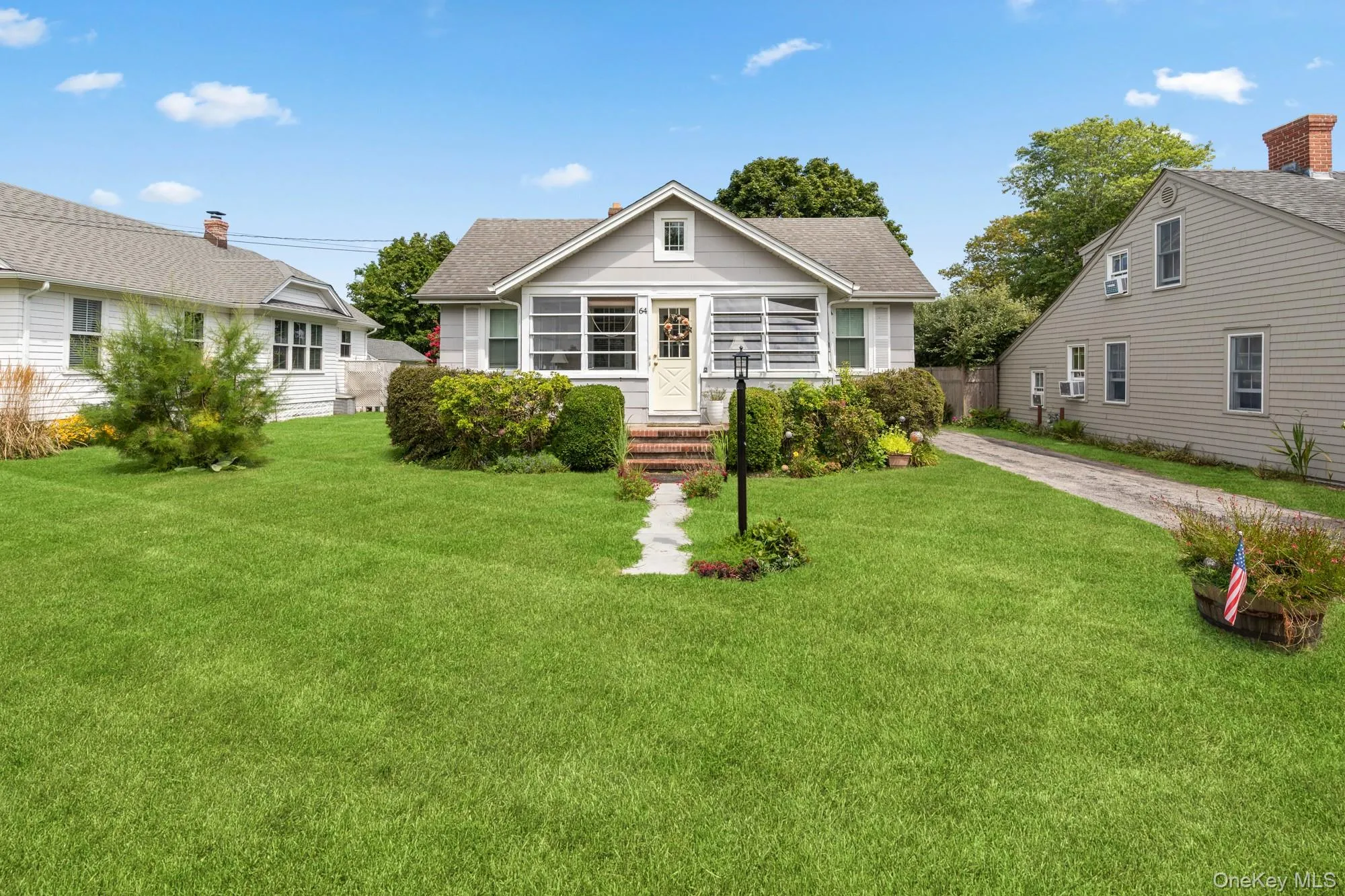 Bungalow-style house with a shingled roof and dirt driveway Bungalow-style house with a shingled roof and dirt driveway