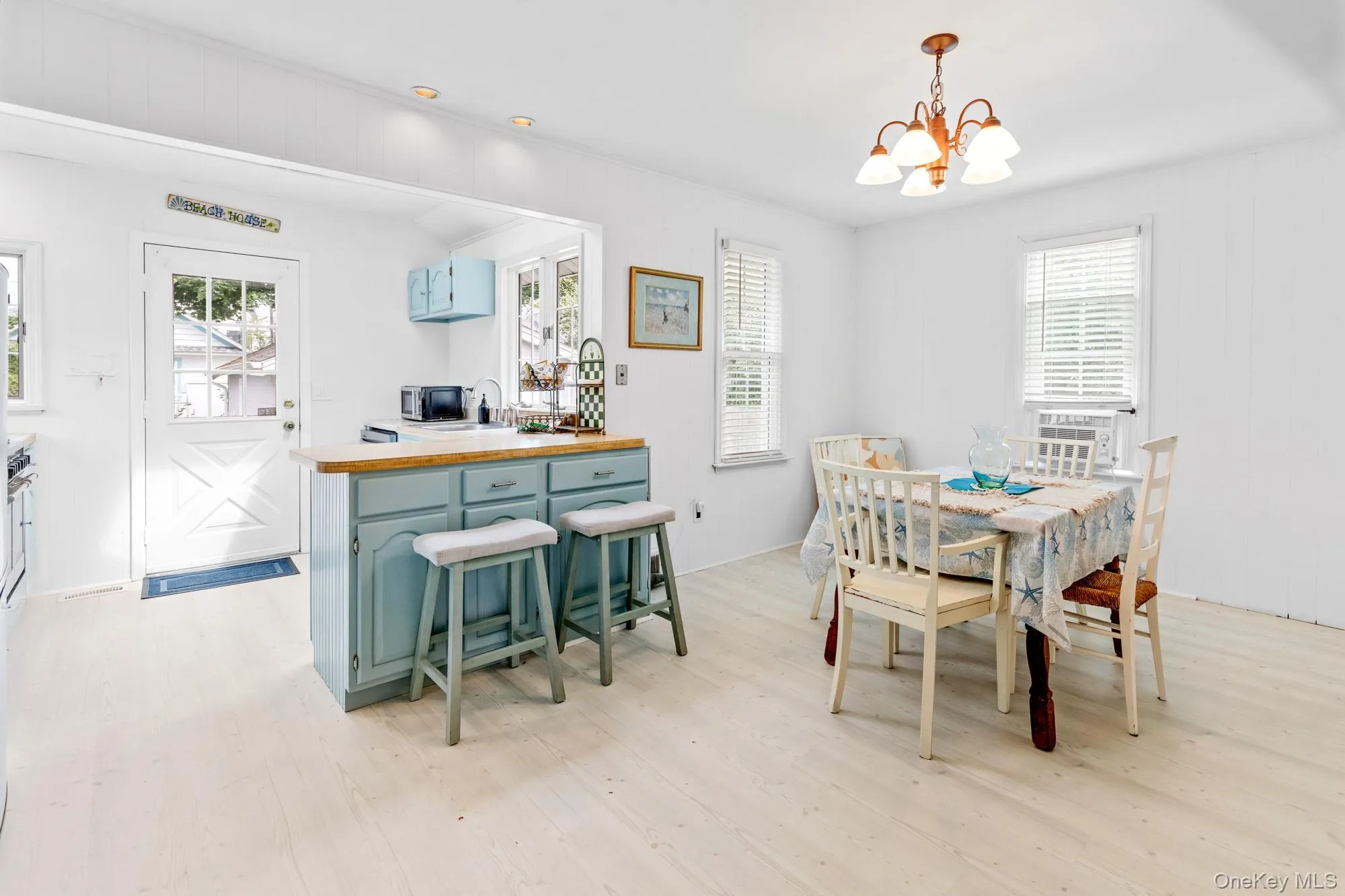 Dining space with plenty of natural light, light wood-style floors, and a chandelier Dining space with plenty of natural light, light wood-style floors, and a chandelier