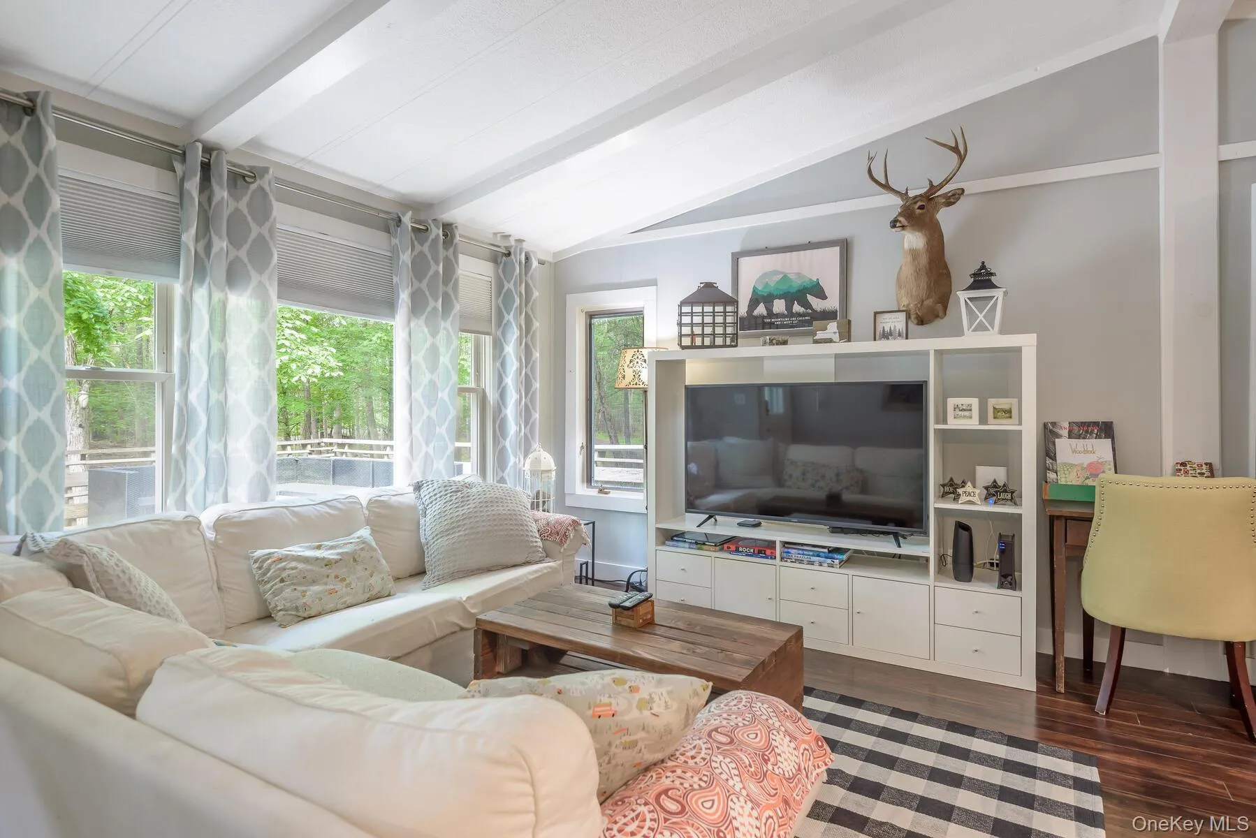 Living area featuring dark wood-type flooring and vaulted ceiling with beams Living area featuring dark wood-type flooring and vaulted ceiling with beams