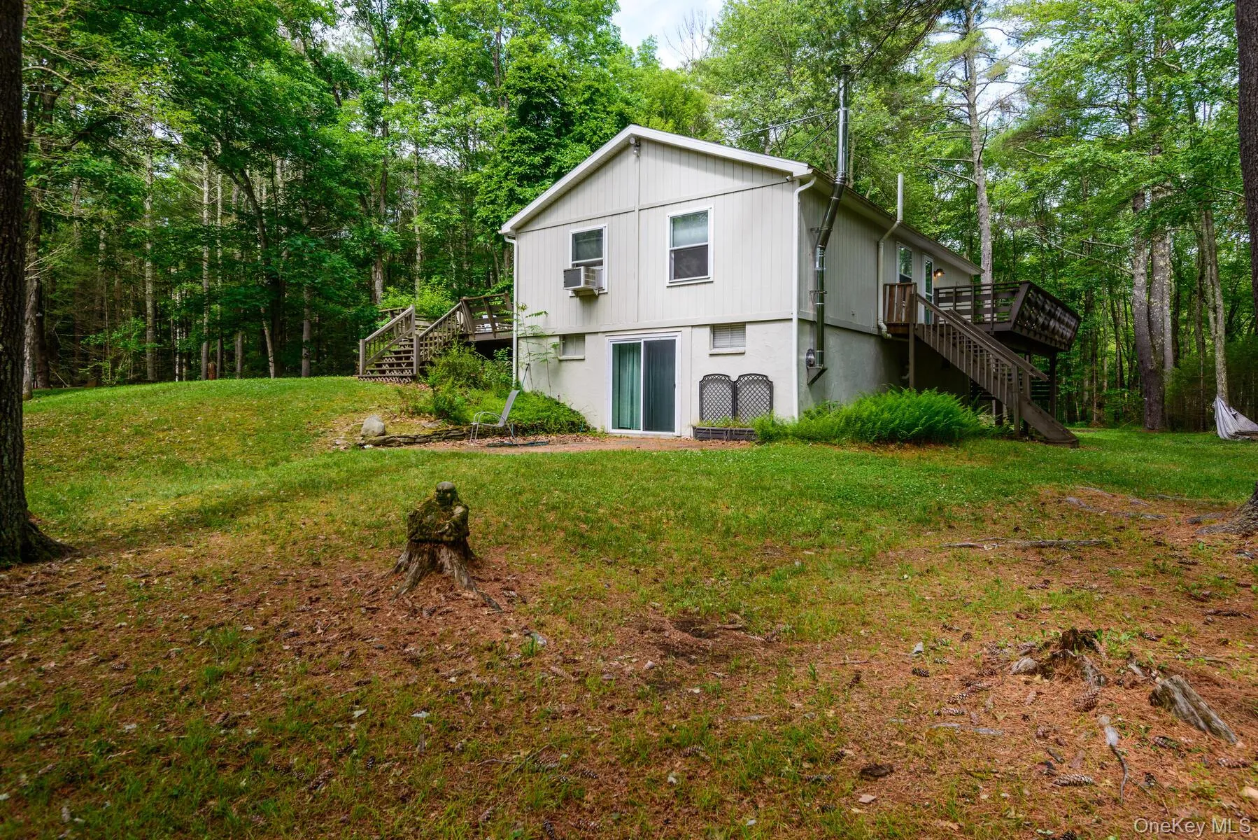 Rear view of property featuring stairs, a deck, cooling unit, and a lawn Rear view of property featuring stairs, a deck, cooling unit, and a lawn