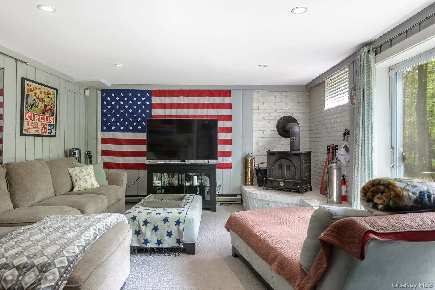 Carpeted living room featuring a wood stove and recessed lighting Carpeted living room featuring a wood stove and recessed lighting