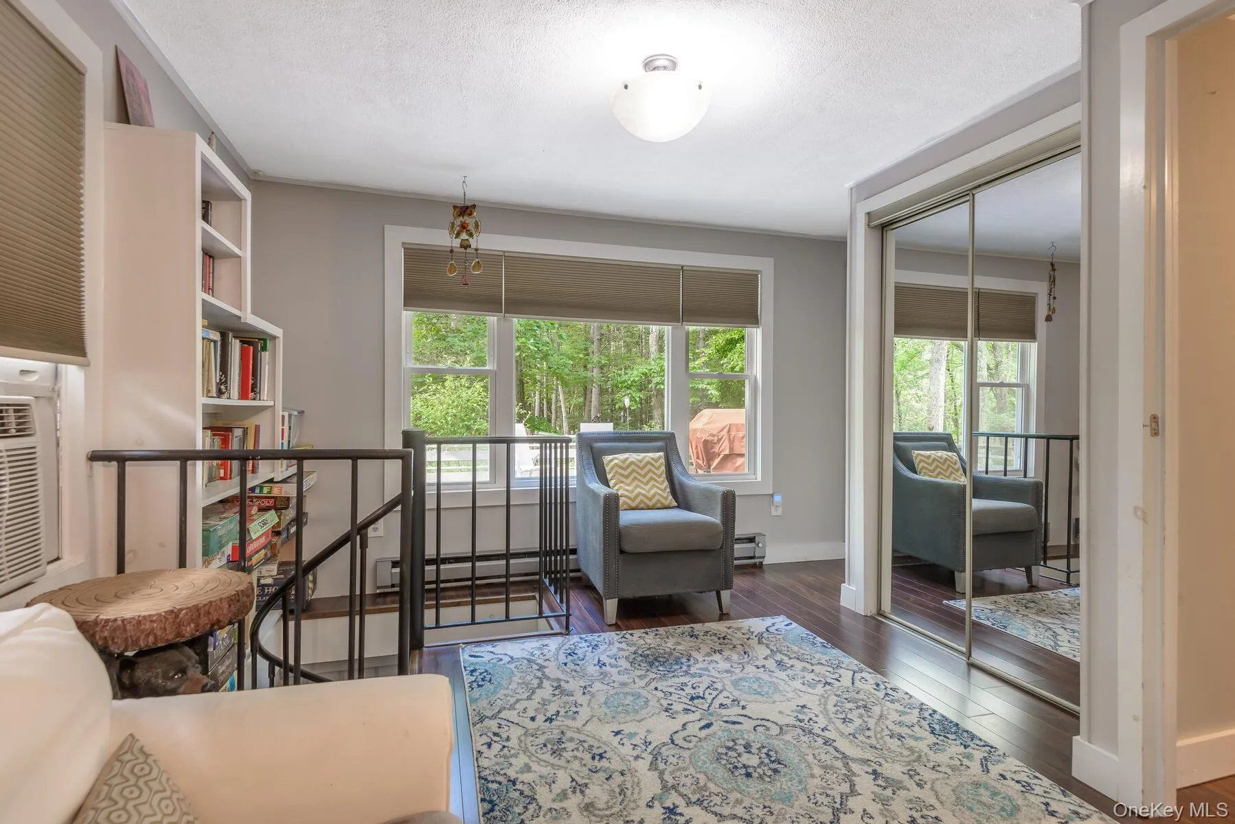 Living area with a baseboard radiator, wood-type flooring, baseboards, and a textured ceiling Living area with a baseboard radiator, wood-type flooring, baseboards, and a textured ceiling