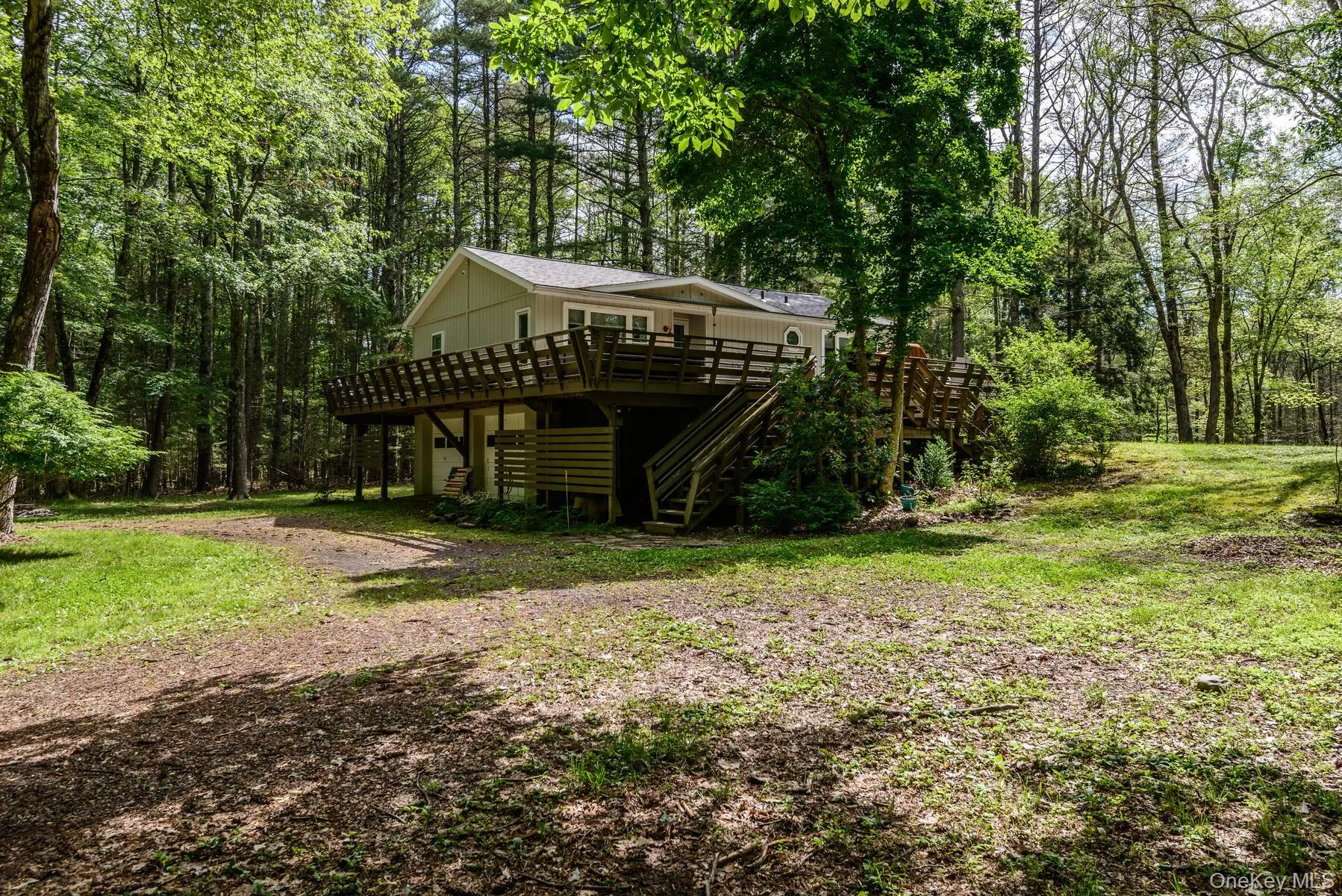 View of yard with a wooded view, stairway, and a wooden deck View of yard with a wooded view, stairway, and a wooden deck