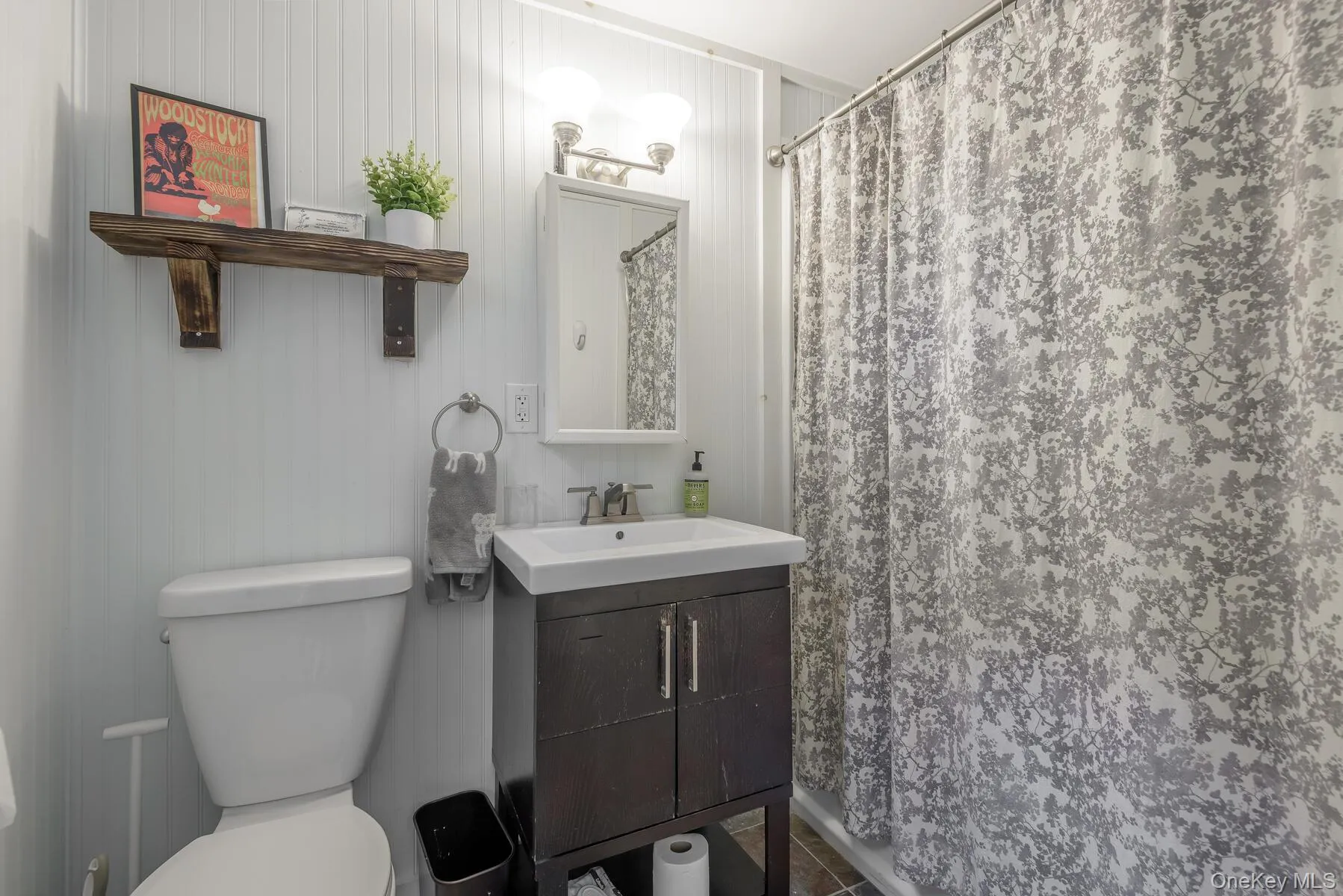 Full bathroom with toilet, vanity, and a shower with shower curtain Full bathroom with toilet, vanity, and a shower with shower curtain