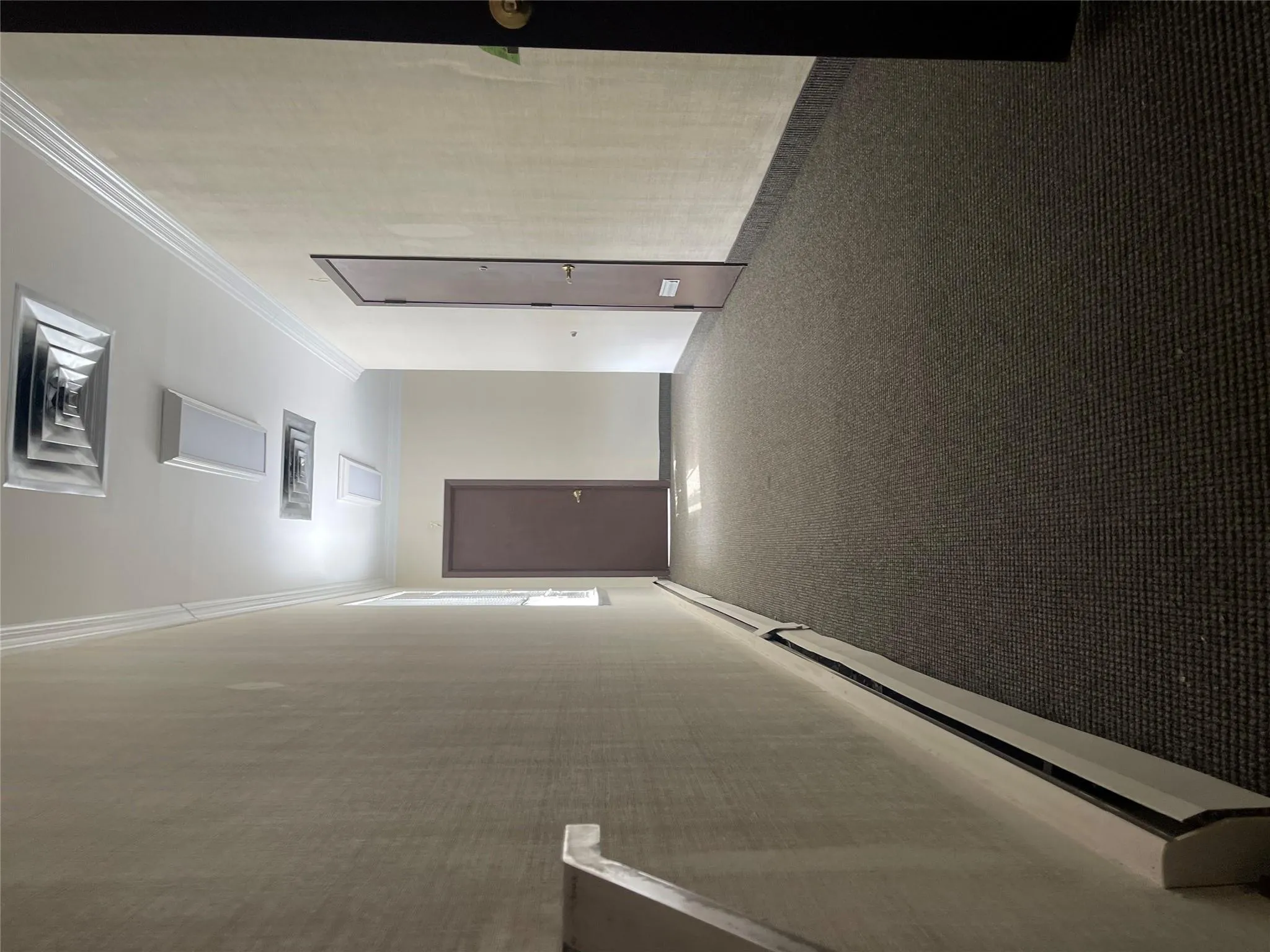 Hall with ornamental molding, carpet flooring, a baseboard heating unit, and visible vents Hall with ornamental molding, carpet flooring, a baseboard heating unit, and visible vents