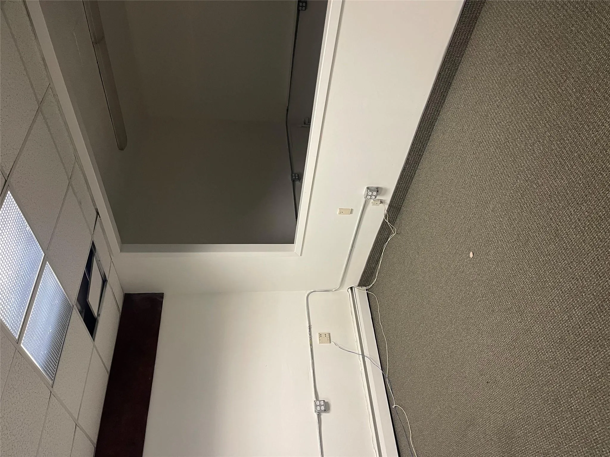 Empty room featuring a paneled ceiling, a baseboard heating unit, baseboards, and carpet floors Empty room featuring a paneled ceiling, a baseboard heating unit, baseboards, and carpet floors