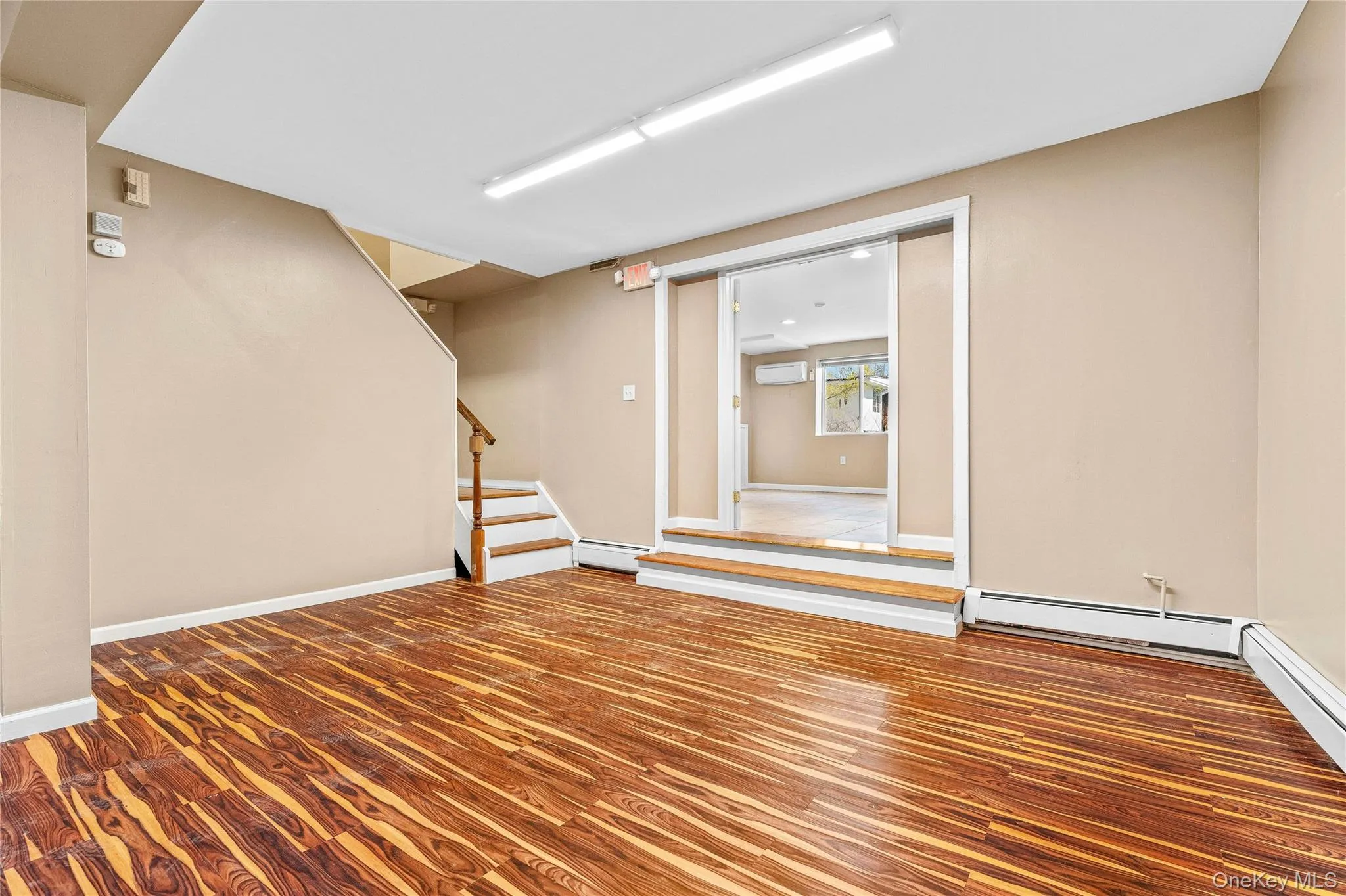 Basement with baseboard heating, baseboards, and stairway Basement with baseboard heating, baseboards, and stairway