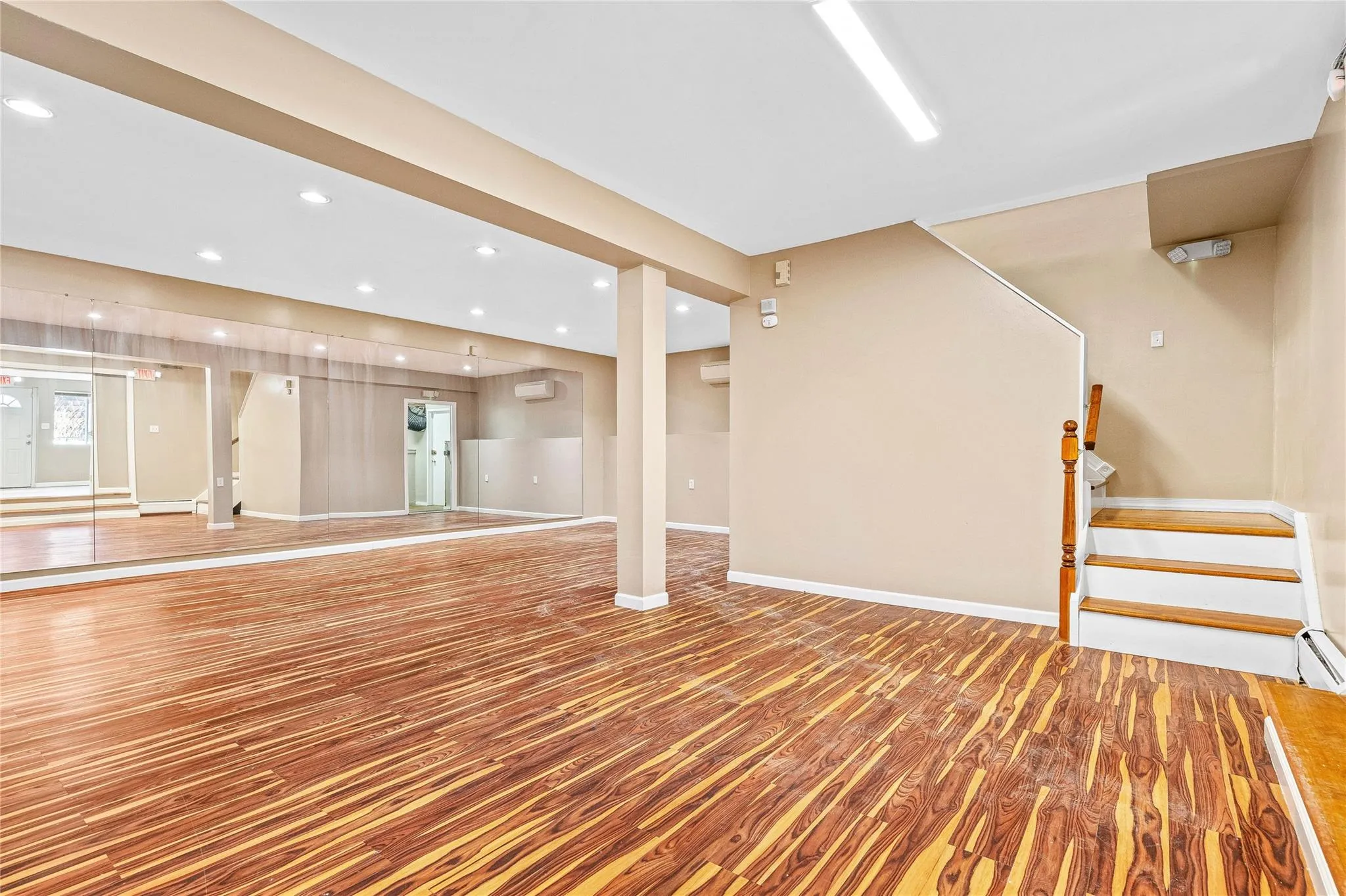 Exercise room with baseboards, a wall unit AC, wood finished floors, and recessed lighting Exercise room with baseboards, a wall unit AC, wood finished floors, and recessed lighting