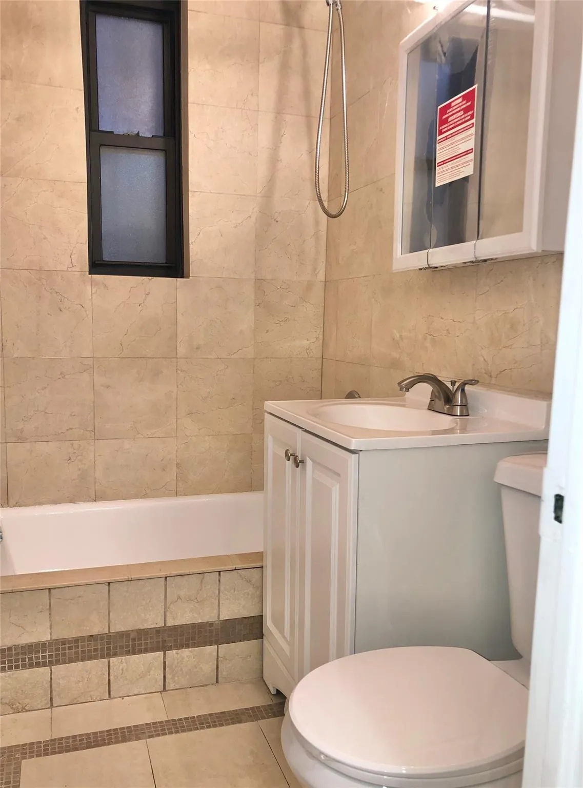 Bathroom featuring tile patterned floors, toilet, tile walls, tiled shower / bath combo, and vanity Bathroom featuring tile patterned floors, toilet, tile walls, tiled shower / bath combo, and vanity