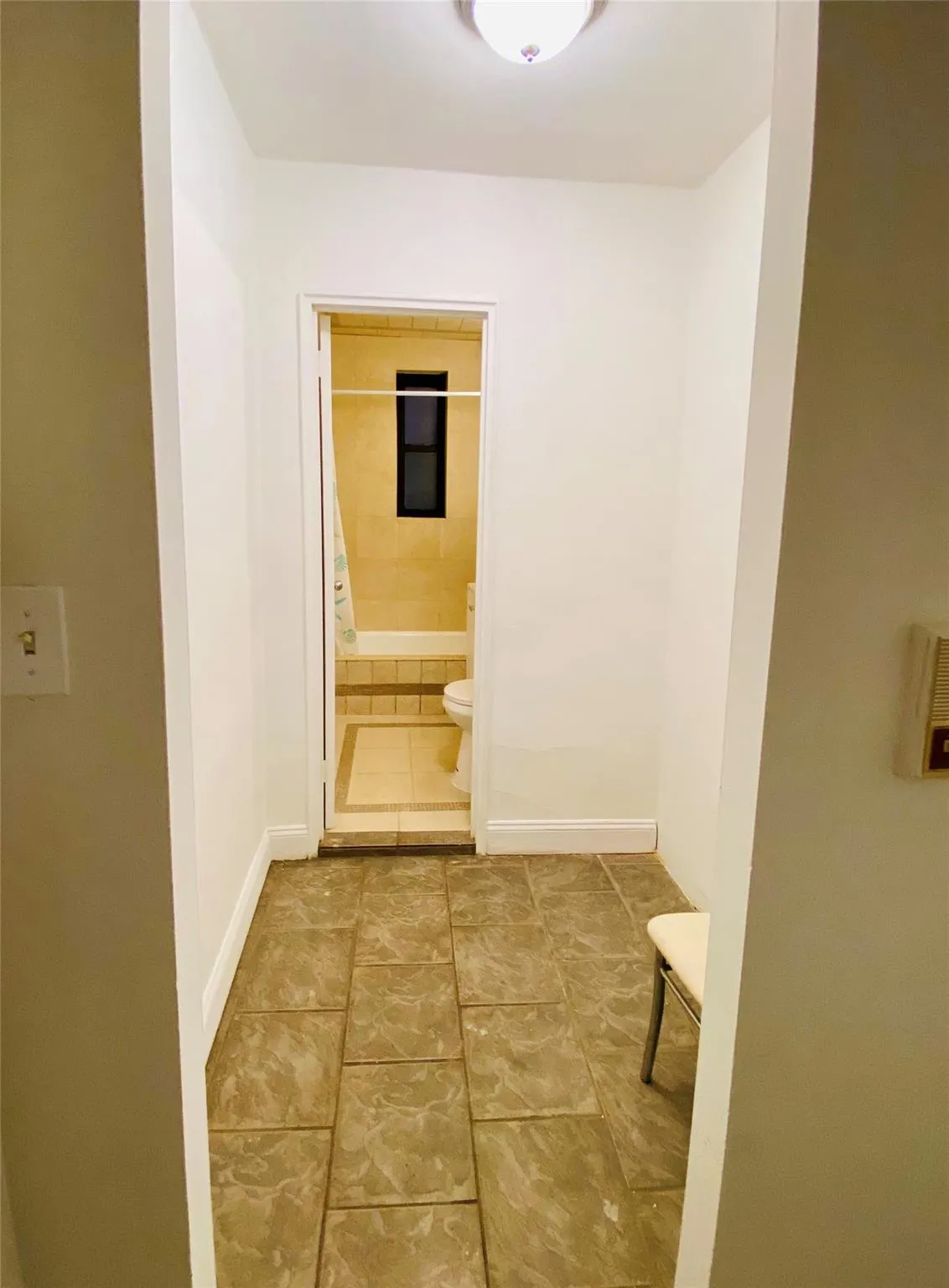 Hall featuring baseboards and tile patterned flooring Hall featuring baseboards and tile patterned flooring
