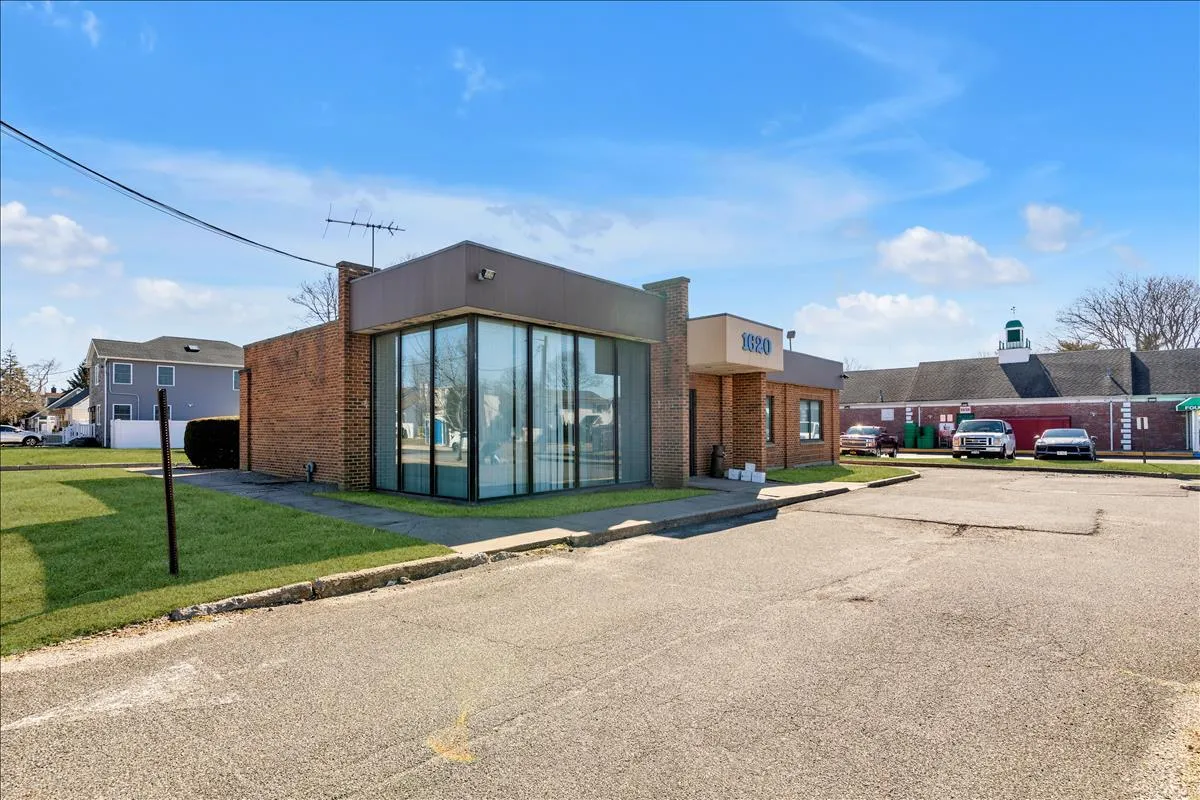 View of building exterior featuring uncovered parking View of building exterior featuring uncovered parking