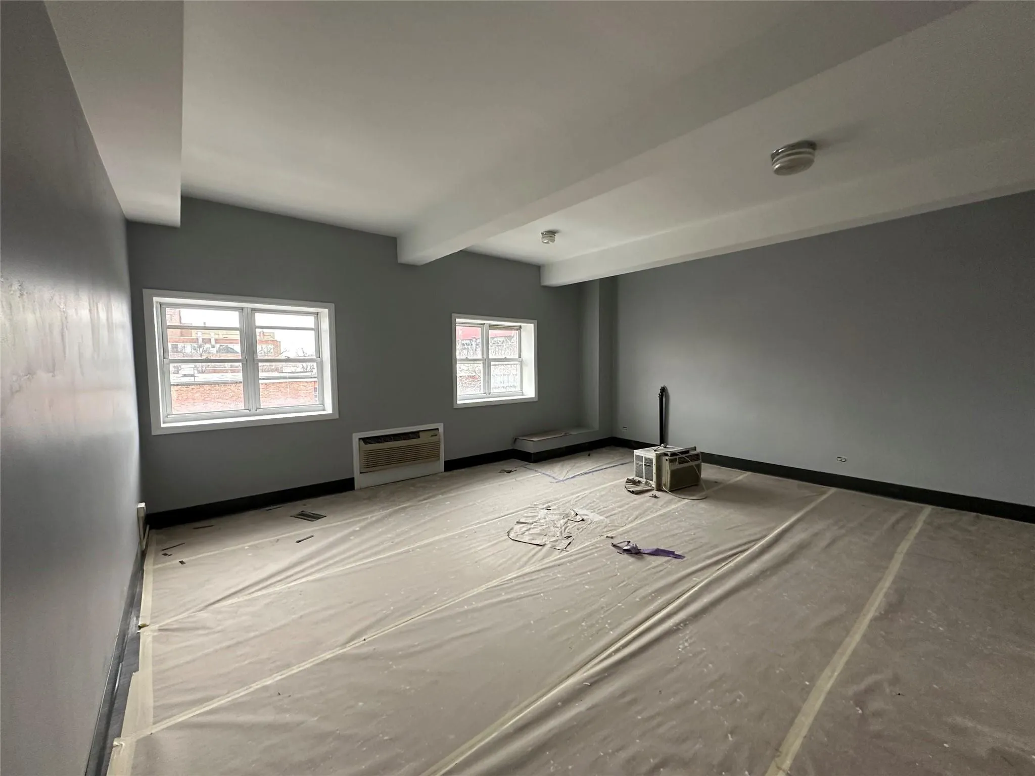 Unfurnished room featuring a wall mounted air conditioner, beam ceiling, baseboards, and visible vents Unfurnished room featuring a wall mounted air conditioner, beam ceiling, baseboards, and visible vents