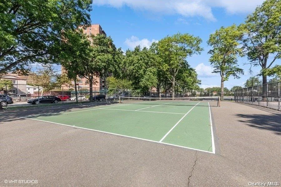 View of tennis court featuring fence View of tennis court featuring fence