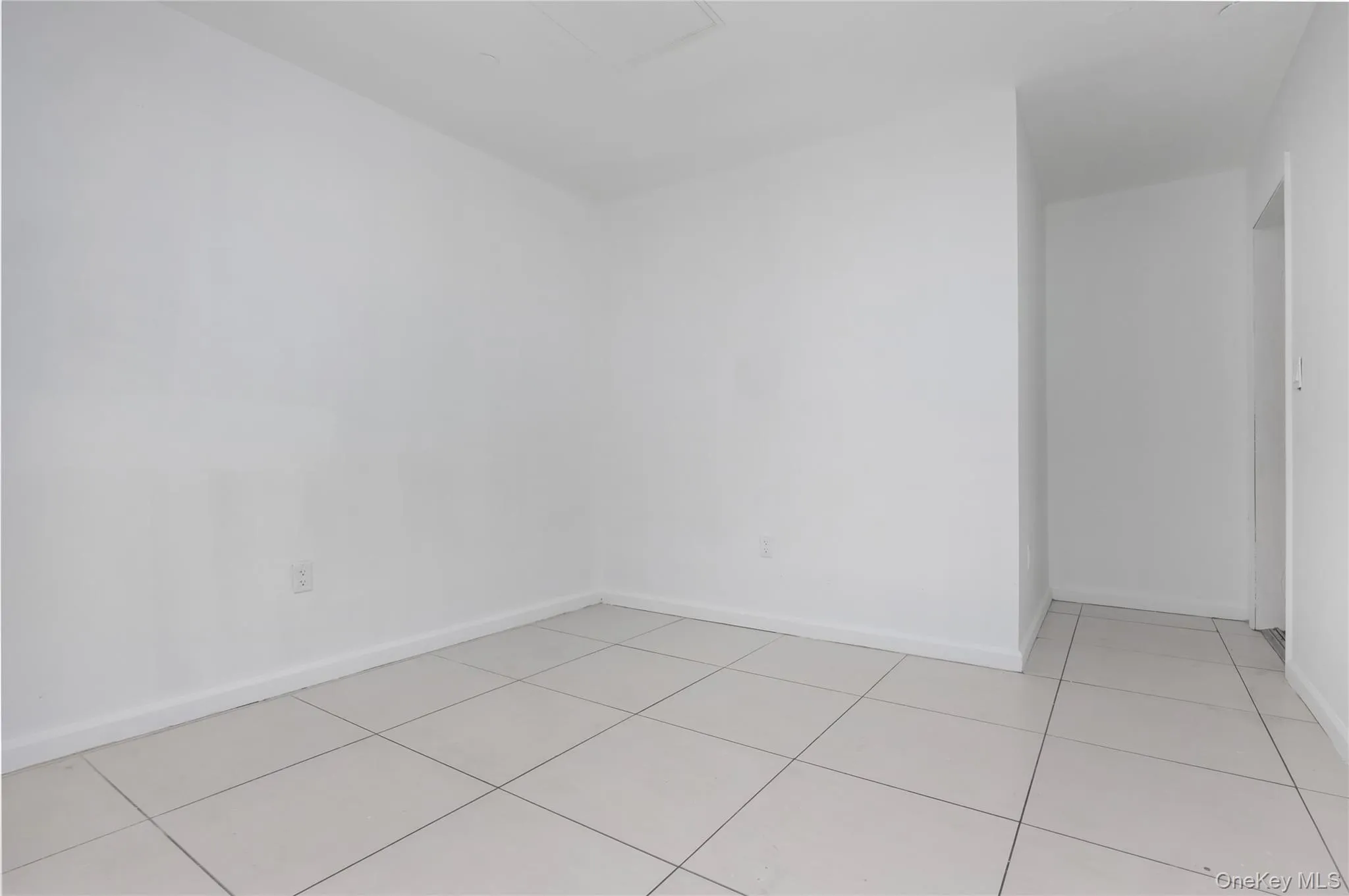 Empty room featuring light tile patterned floors and baseboards Empty room featuring light tile patterned floors and baseboards
