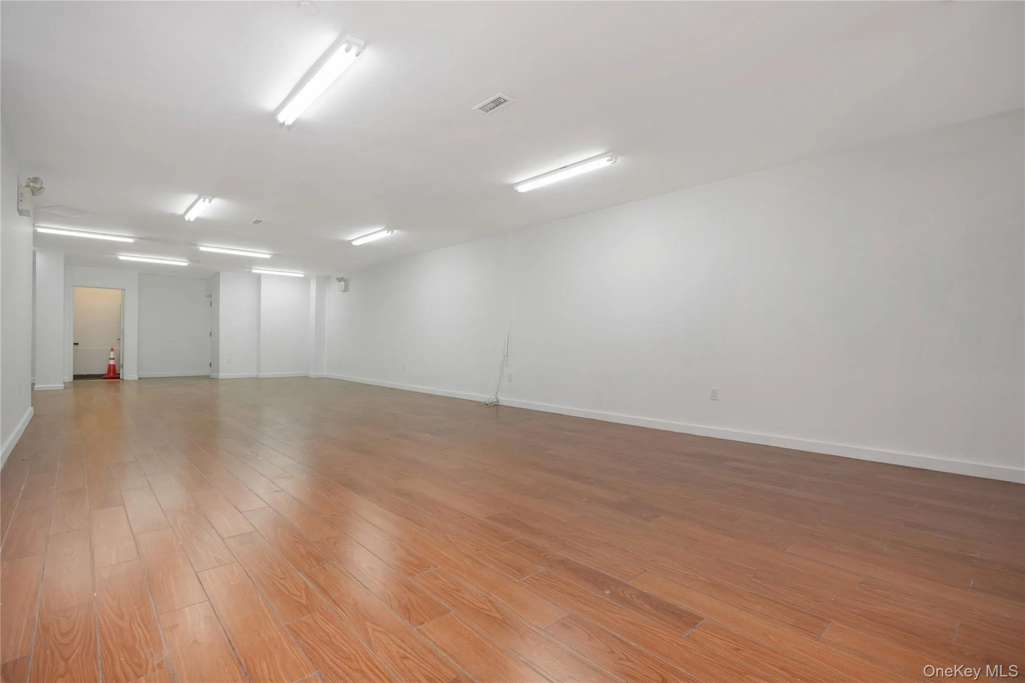 Spare room featuring light wood-type flooring and baseboards Spare room featuring light wood-type flooring and baseboards