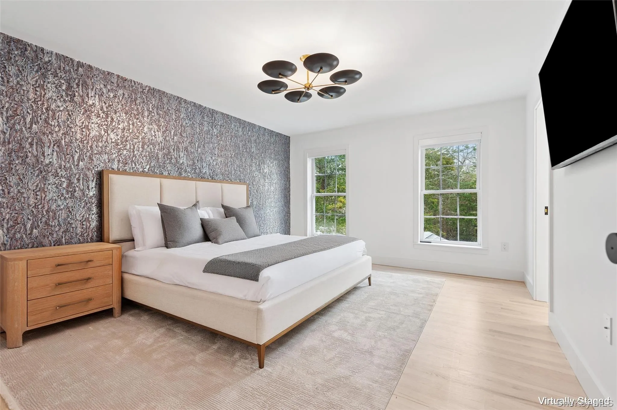 Bedroom with an accent wall, wallpapered walls, a chandelier, light wood-style floors, and baseboards Bedroom with an accent wall, wallpapered walls, a chandelier, light wood-style floors, and baseboards