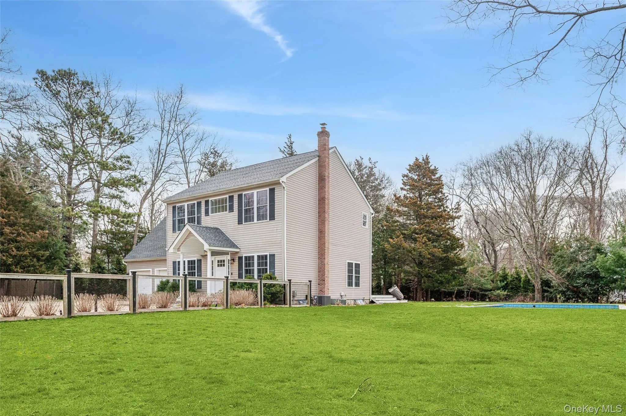 View of front of property with central AC, a chimney, a front lawn, and fence View of front of property with central AC, a chimney, a front lawn, and fence
