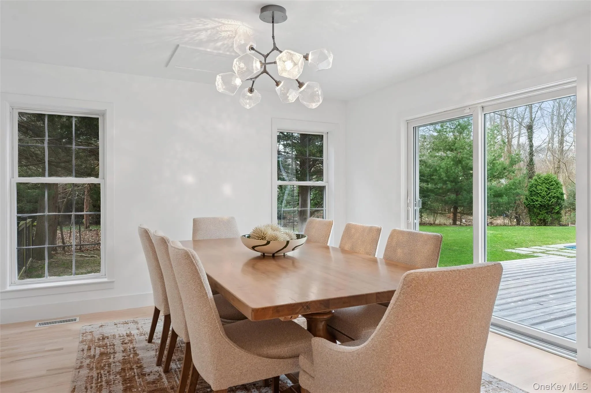 Dining space with an inviting chandelier, a healthy amount of sunlight, light wood-style floors, and visible vents Dining space with an inviting chandelier, a healthy amount of sunlight, light wood-style floors, and visible vents