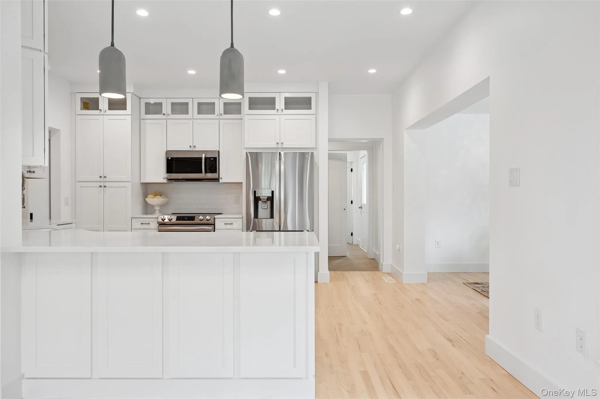 Kitchen featuring recessed lighting, light countertops, baseboards, and stainless steel appliances Kitchen featuring recessed lighting, light countertops, baseboards, and stainless steel appliances