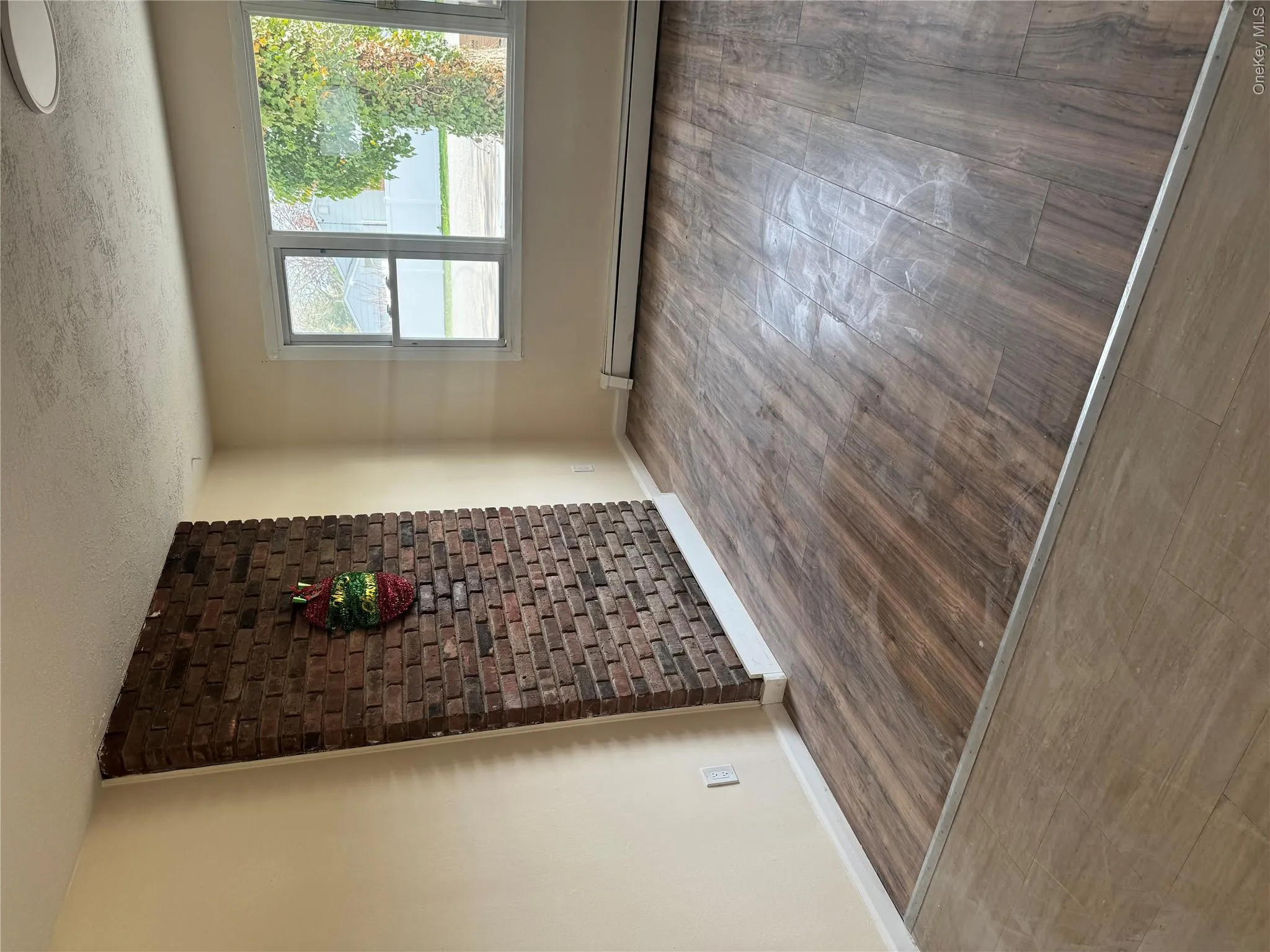 Unfurnished room with a textured ceiling, baseboards, wood finished floors, and a baseboard radiator Unfurnished room with a textured ceiling, baseboards, wood finished floors, and a baseboard radiator