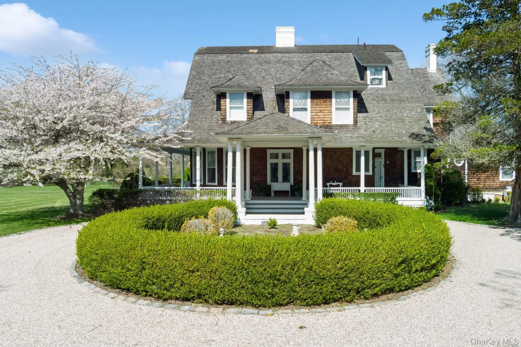 View of front of home with a chimney, a shingled roof, covered porch, and a gambrel roof View of front of home with a chimney, a shingled roof, covered porch, and a gambrel roof