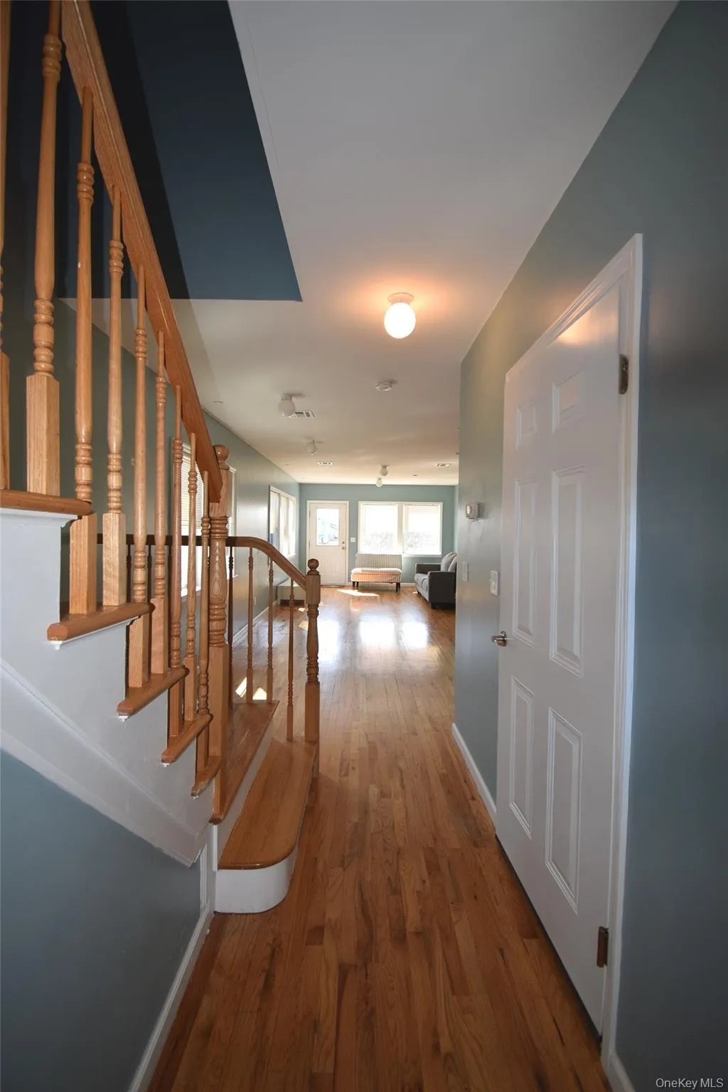 Hallway featuring baseboards, wood finished floors, and stairs Hallway featuring baseboards, wood finished floors, and stairs