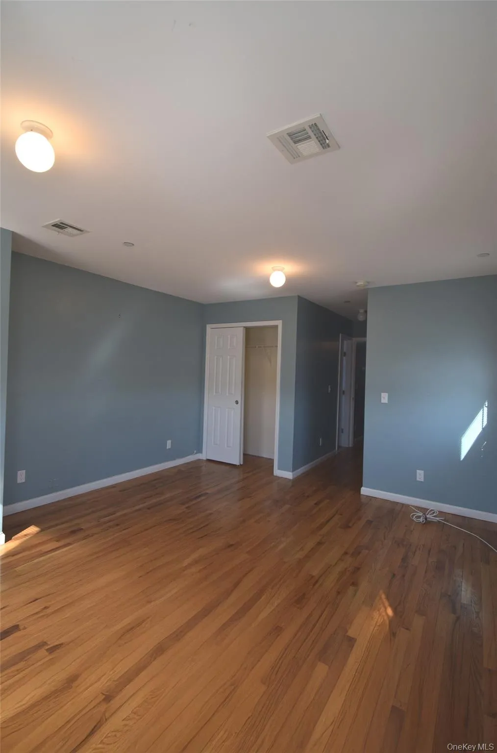 Upstairs Large main bedroom with closets and wood finished floors, visible vents, and baseboards Upstairs Large main bedroom with closets and wood finished floors, visible vents, and baseboards