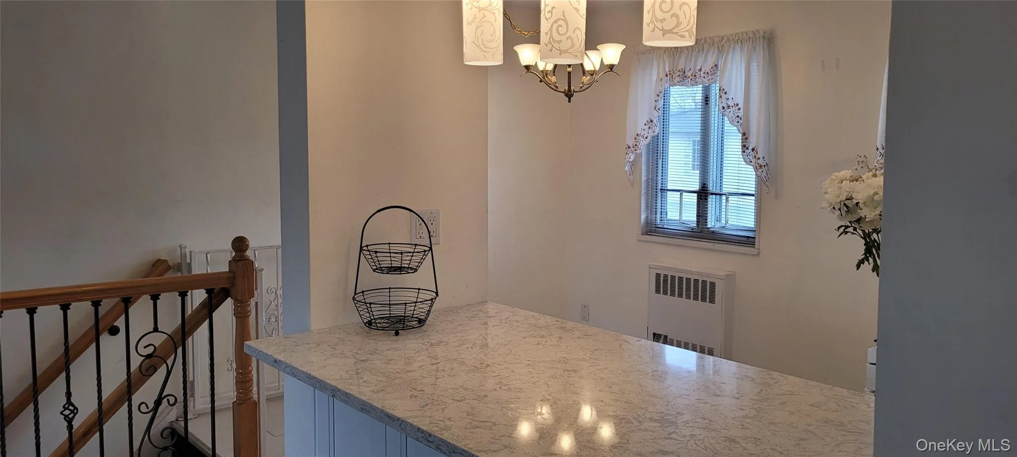 Dining area featuring a notable chandelier and radiator heating unit Dining area featuring a notable chandelier and radiator heating unit