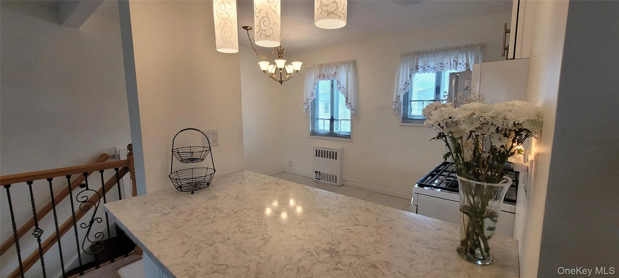 Tiled dining space with baseboards, radiator heating unit, and a chandelier Tiled dining space with baseboards, radiator heating unit, and a chandelier