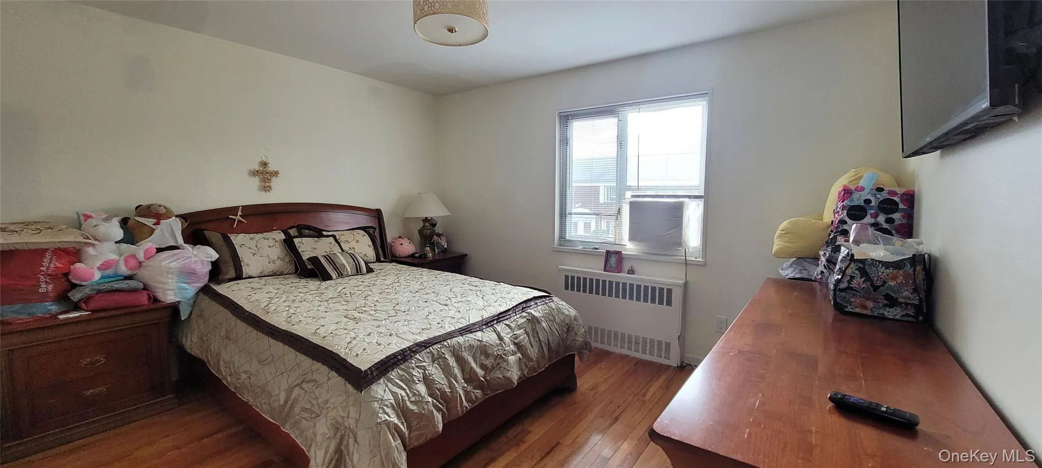 Bedroom with radiator and wood finished floors Bedroom with radiator and wood finished floors