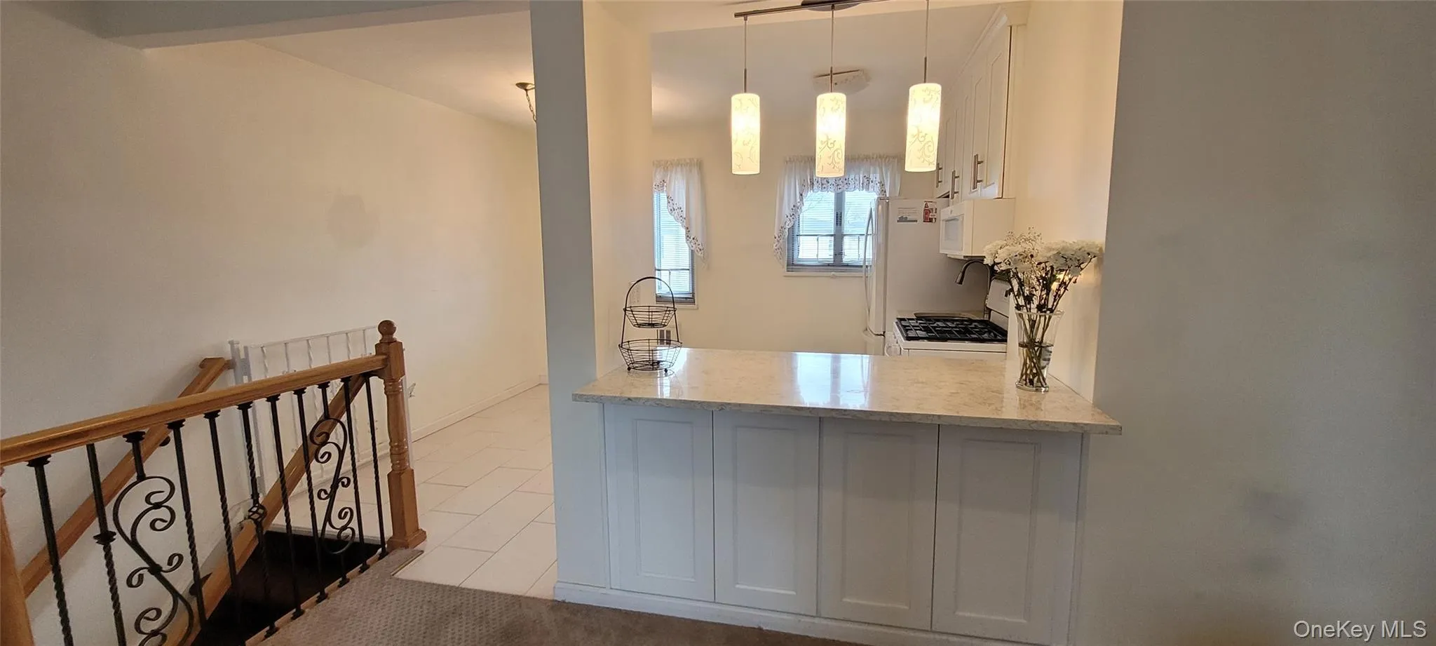 Bar with tile patterned floors, decorative light fixtures, and white microwave Bar with tile patterned floors, decorative light fixtures, and white microwave