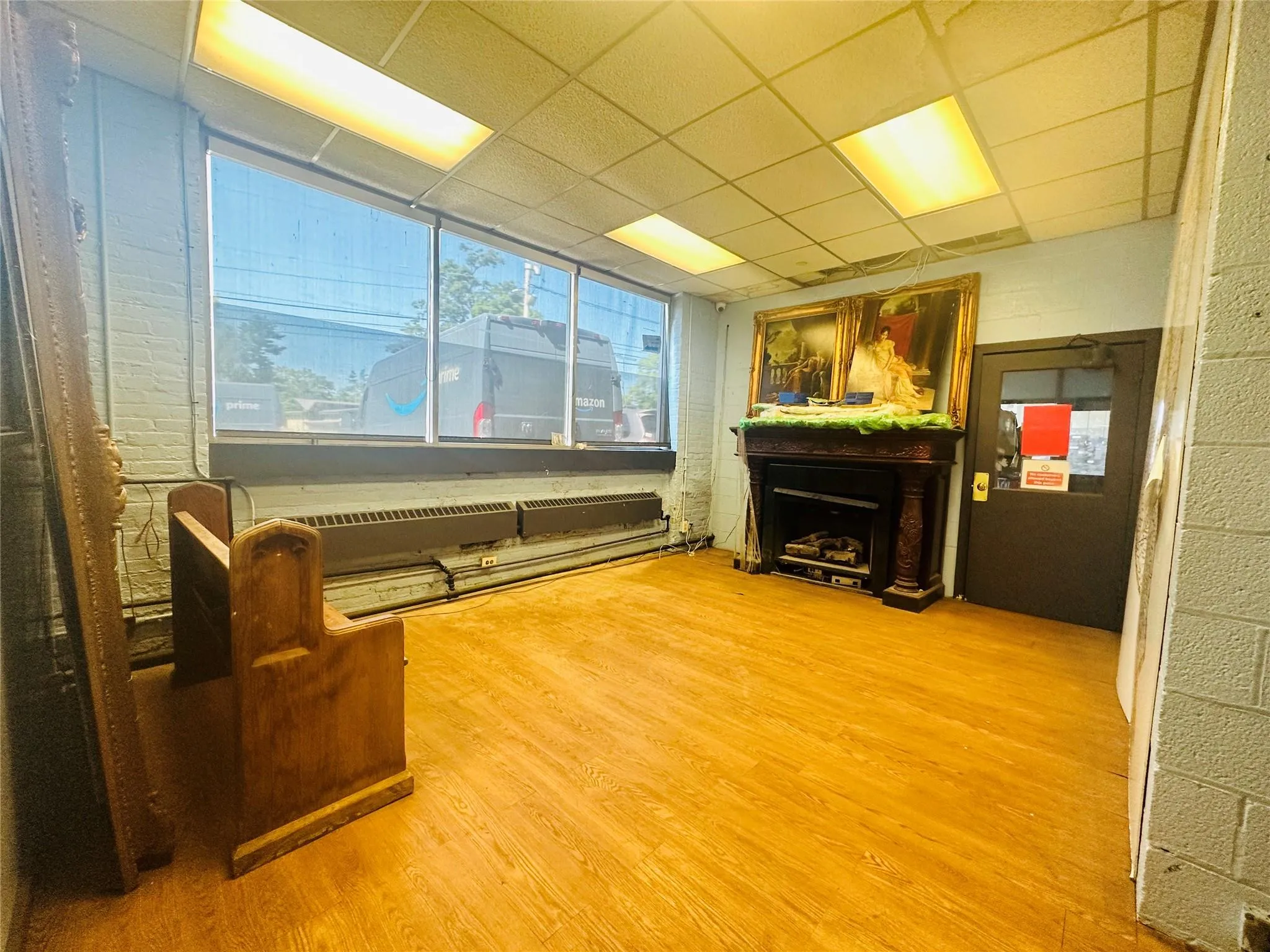 Sitting room with wood finished floors, a fireplace, and a drop ceiling Sitting room with wood finished floors, a fireplace, and a drop ceiling