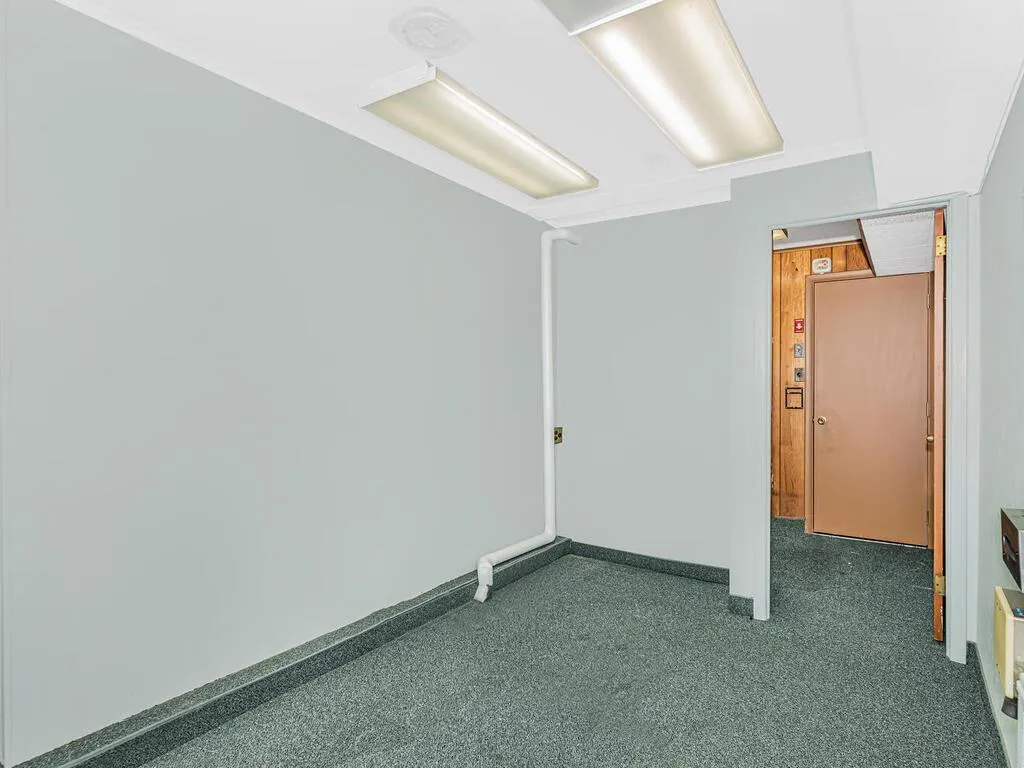 Spare room with dark colored carpet, baseboards, and ornamental molding Spare room with dark colored carpet, baseboards, and ornamental molding