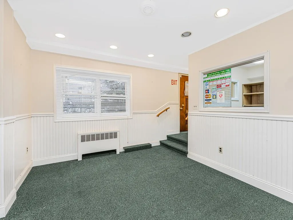 Carpeted spare room with wainscoting, radiator heating unit, and recessed lighting Carpeted spare room with wainscoting, radiator heating unit, and recessed lighting