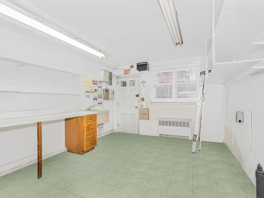 Basement featuring radiator heating unit and light floors Basement featuring radiator heating unit and light floors
