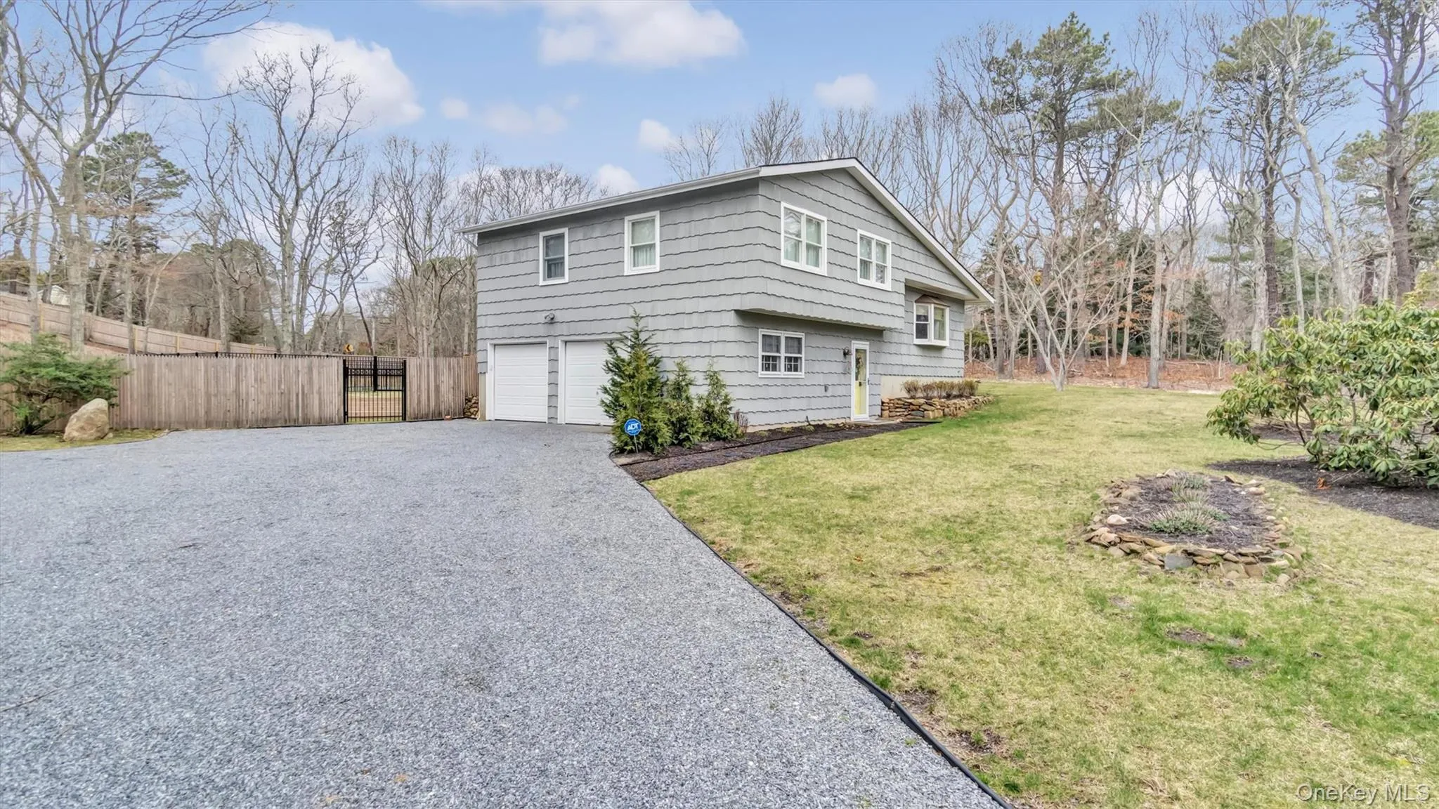 View of side of home with an attached garage, a lawn, aphalt driveway, and fence View of side of home with an attached garage, a lawn, aphalt driveway, and fence