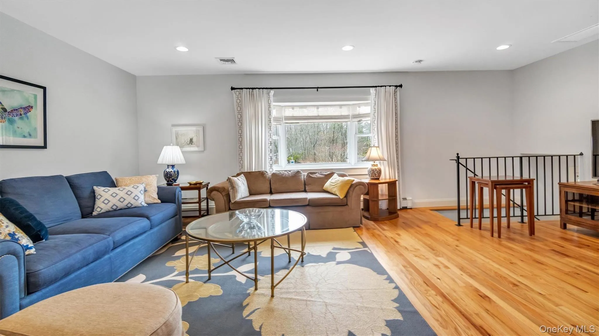 Living room featuring recessed lighting, visible vents, and light wood-style flooring Living room featuring recessed lighting, visible vents, and light wood-style flooring