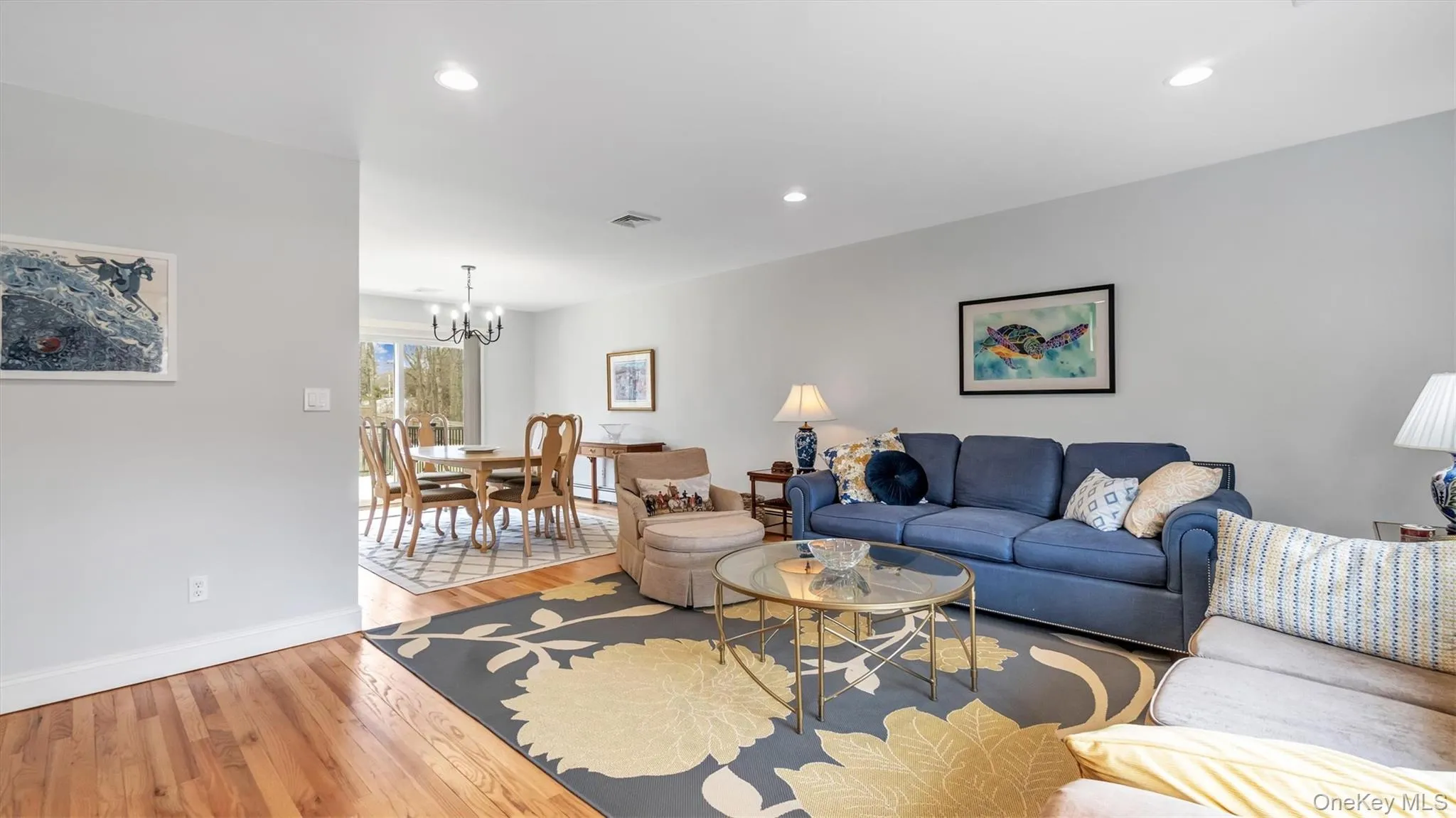 Living area featuring recessed lighting, visible vents, baseboards, a chandelier, and light wood-style flooring Living area featuring recessed lighting, visible vents, baseboards, a chandelier, and light wood-style flooring