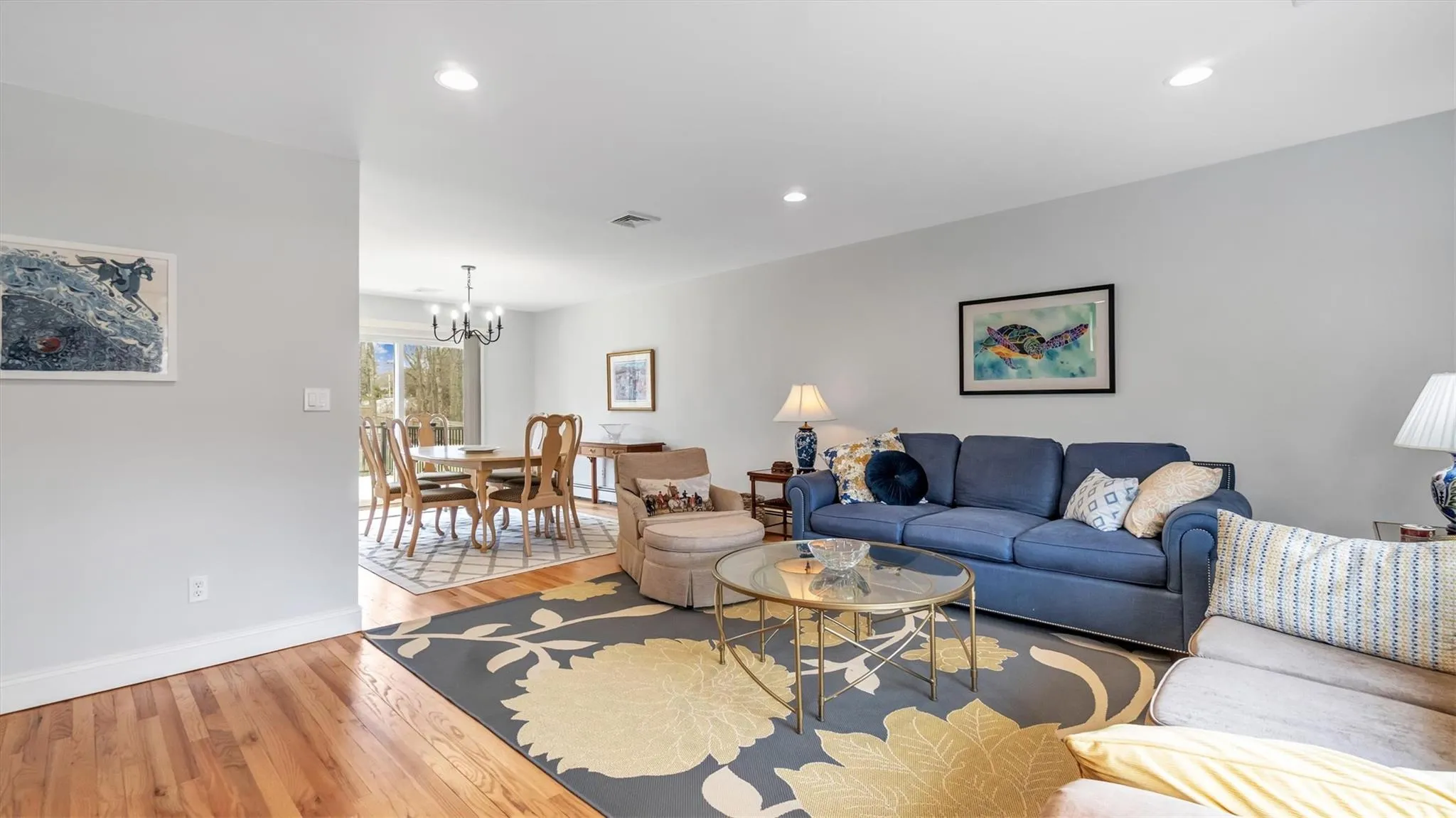 Living area featuring recessed lighting, visible vents, baseboards, a chandelier, and light wood-style flooring Living area featuring recessed lighting, visible vents, baseboards, a chandelier, and light wood-style flooring