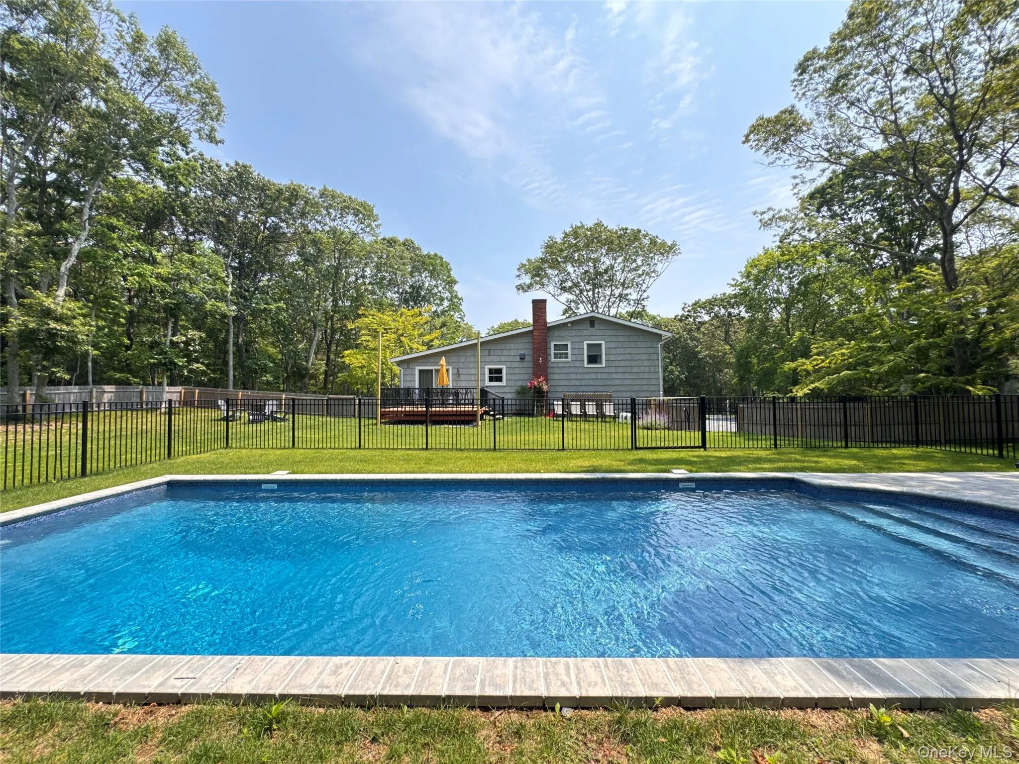 View of pool featuring a wooden deck View of pool featuring a wooden deck