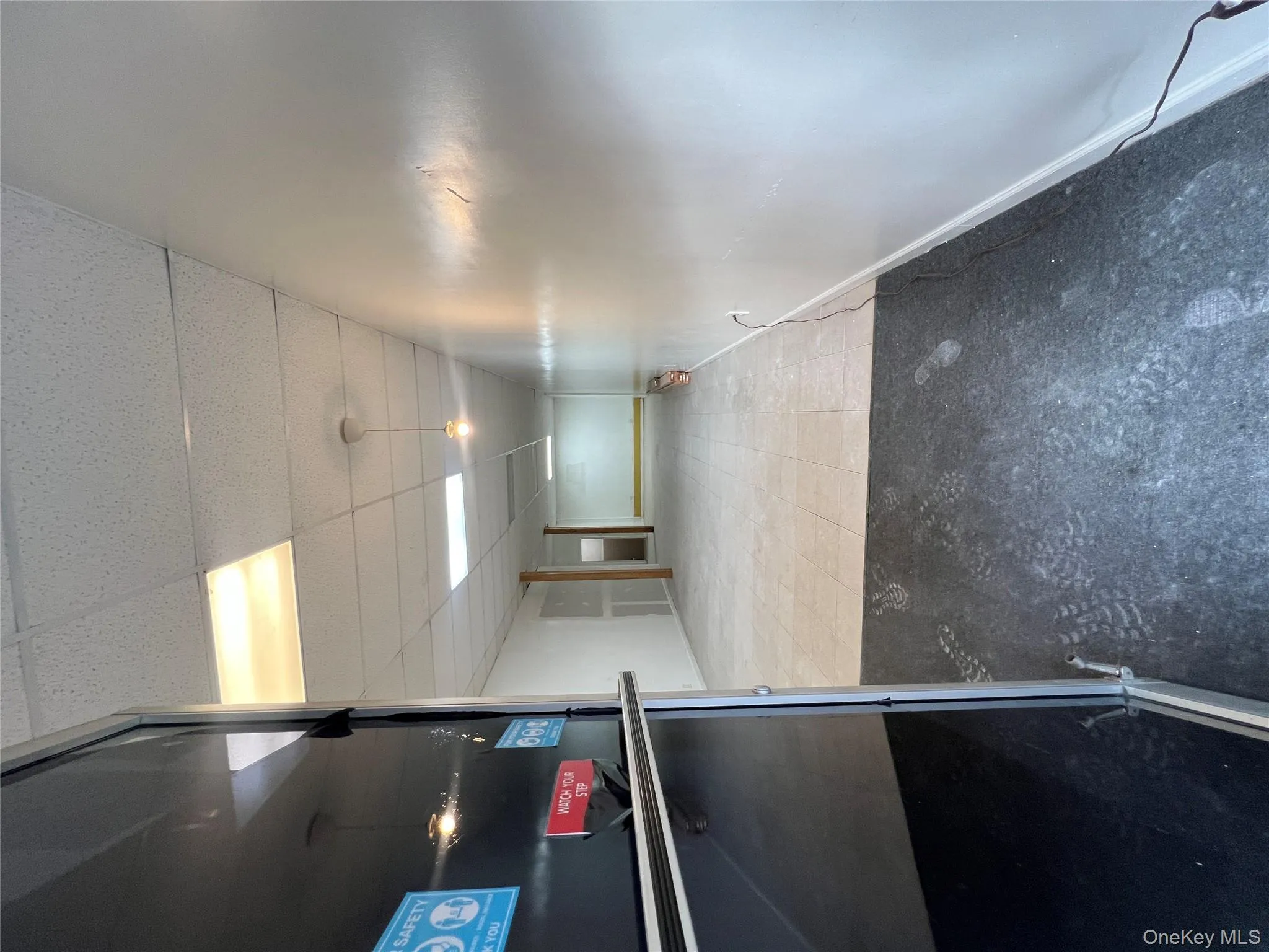 Corridor featuring baseboards and a paneled ceiling Corridor featuring baseboards and a paneled ceiling